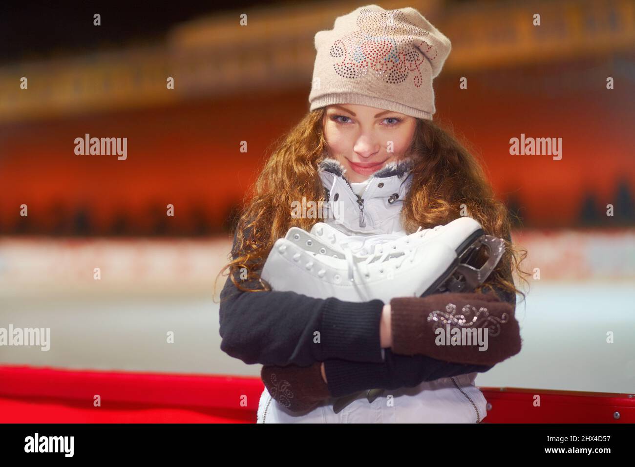 Divertimento invernale sulla pista. Ritratto di una bella giovane donna in piedi in una pista di pattinaggio su ghiaccio. Foto Stock