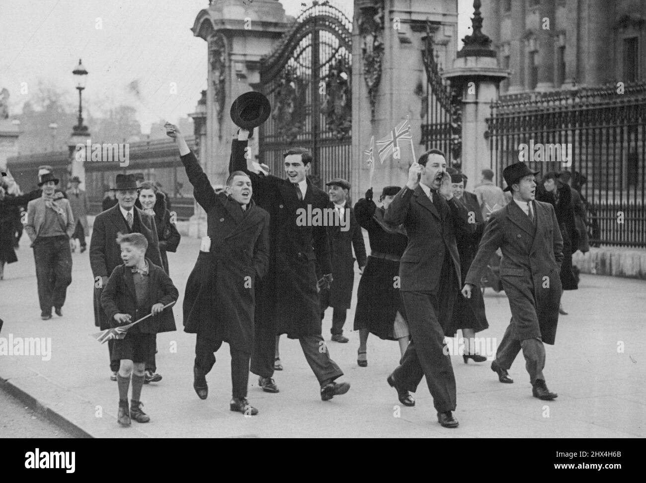 Dimostrazione patriottica fuori Buckingham Palace Foto mostra:- giovani uomini che marciavano su e giù fuori Buckingham Palace questo pomeriggio ondeggiando Union Jacks e cantando 'God Save the King'. Una manifestazione patriottica si è svolta fuori da Buckingham Palace. Londra, S.W., questo pomeriggio, quando un certo numero di giovani uomini marciarono su e giù per il marciapiede fuori dal palazzo cantando "Dio Salva il Re" e agitando Union Jacks. Dicembre 04, 1936. (Foto di Topical Press). Foto Stock