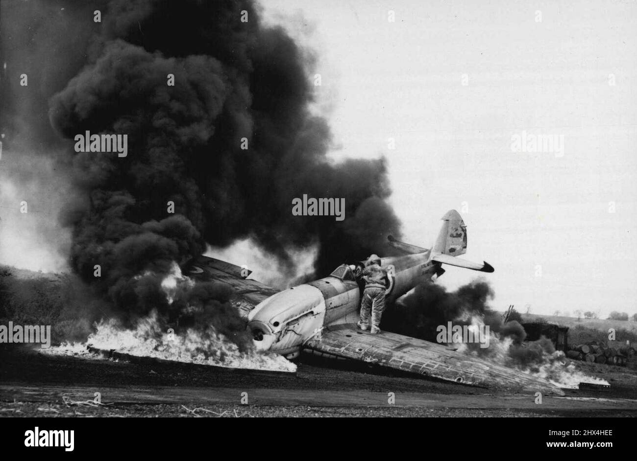 Un brivido al 'Chatham Navy Days' - uno dei molti brividi durante una dimostrazione da parte dei vigili del fuoco Navali. Indossando una tuta in amianto un membro della squadra rescue un 'pilota' dal suo aereo in fiamme. I membri del pubblico potranno vedere i molti e vari aspetti della vita nella Royal Navy al 'Chatham Navy Days' che si svolge presso la Chatham (Kent) stabilimento navale. Mostre, mostre e dimostrazioni si terranno durante i tre giorni dei "Chatham Navy Days". Aprile 19, 1954. Foto Stock