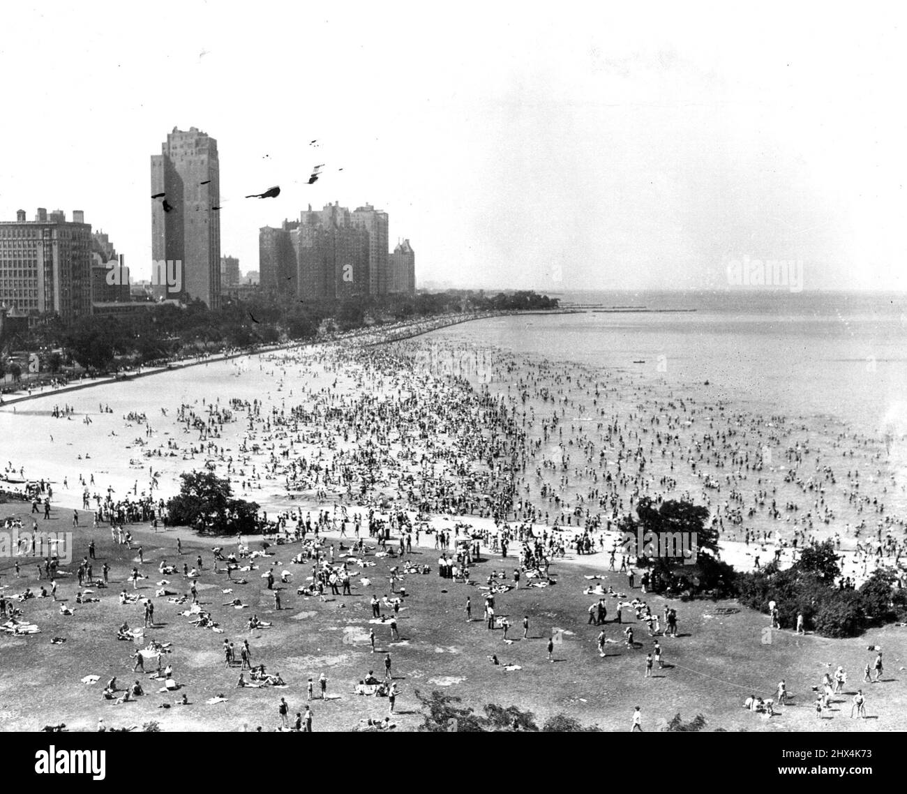 I Chicagoans cercano il rilievo di calore con il sol vecchio blistering i marciapiedi a Chicago, 20 giugno, i bootleggers, i gangster e la gente comune fuggiti alle spiagge. Qui è una scena lungo il lago Michigan Waterfront, presso il più grande locale balneare della città. Giugno 21, 1933. (Foto di stampa associata). Foto Stock