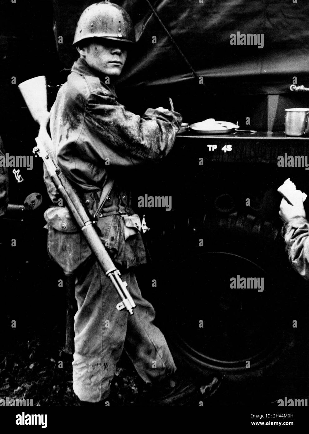 Il soldato Field-Happy si ferma per il chow. Anche se freddo, bagnato e stanco, è fiducioso. Come Sgt. Bohannan dice: "Credo che nessuno dietro la cortina di ferro possa leccarmi". Gennaio 1, 1955. (Foto di Look Magazine). Foto Stock