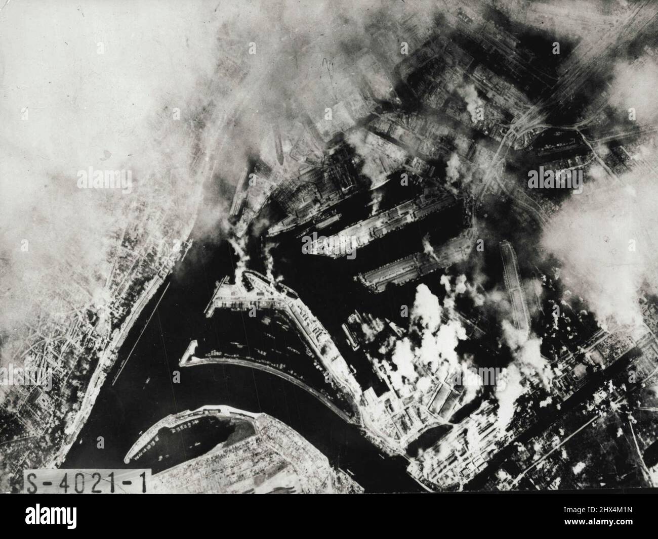 Storia della guerra - 18 -- Amburgo, quando questa foto aerea è stata presa da una Fortezza volante americana, era la città più pesantemente bombardata delle sue dimensioni nel mondo. Era stato quindi modo praticamente inutile come un centro militare, manifatturiero e marittimo. Muovendosi attraverso la cortina di fumo sulla città, le fortezze americane hanno seguito una serie di bombardamenti coperta dagli Alleati, e in questo raid hanno intaccato i cantieri sottomarini Howaldstwerke. Agosto 1, 1945. Foto Stock
