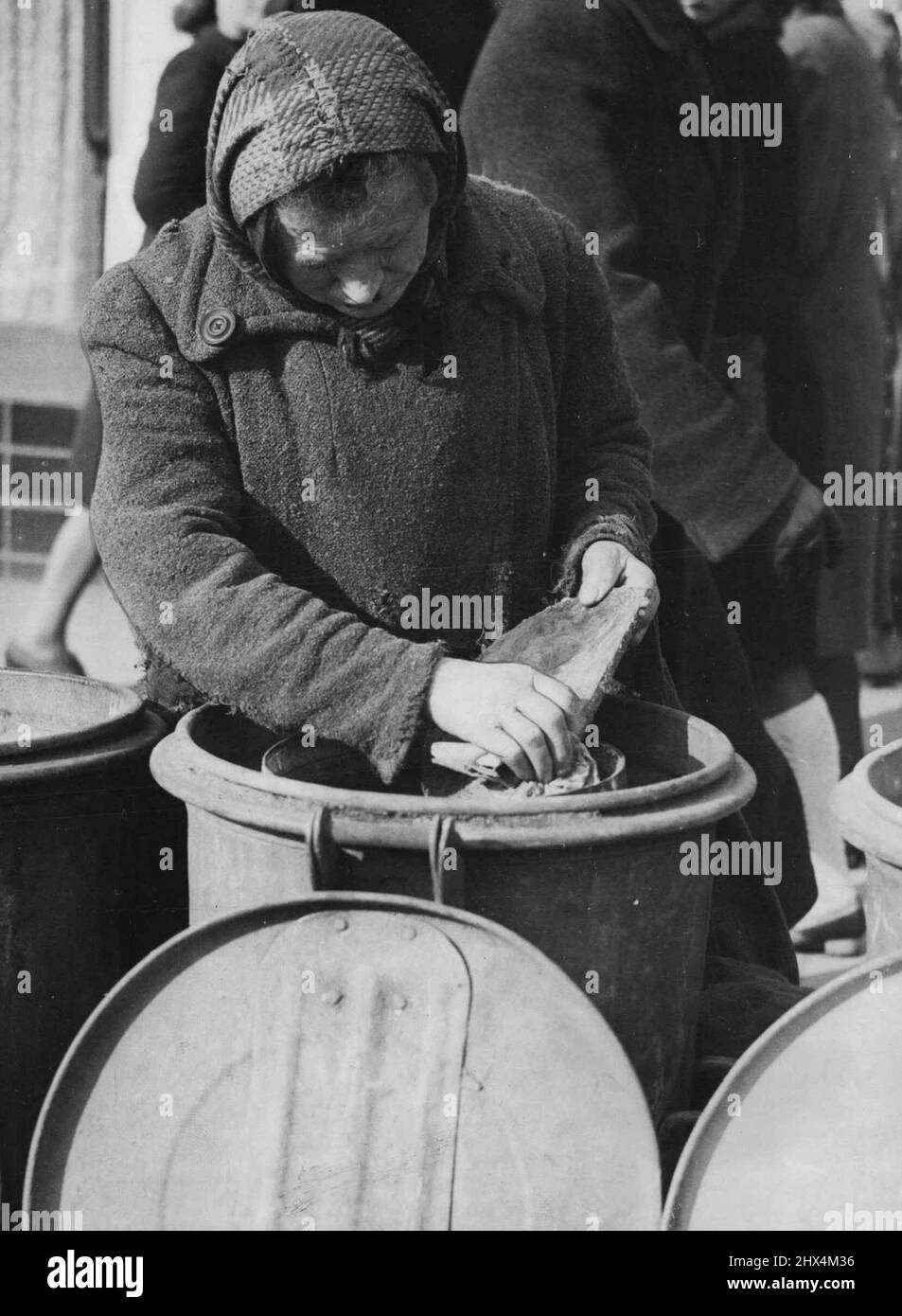 La fame ad Amburgo -- una vecchia donna di Amburgo, Germania, esamina una spazzatura nella zona dei porti durante la sua ricerca di cibo. La città è stata duramente colpita da ***** le restrizioni e la carenza di cibo hanno portato a piccoli disordini e a una serie di casi di saccheggio. Foraging per il cibo in bidoni di spazzatura ad Amburgo. La Germania è un lavoro a tempo pieno (o questa vecchia donna). La scarsità di cibo ad Amburgo ha causato saccheggi e piccoli disordini. Aprile 1, 1946. (Foto di stampa associata). Foto Stock