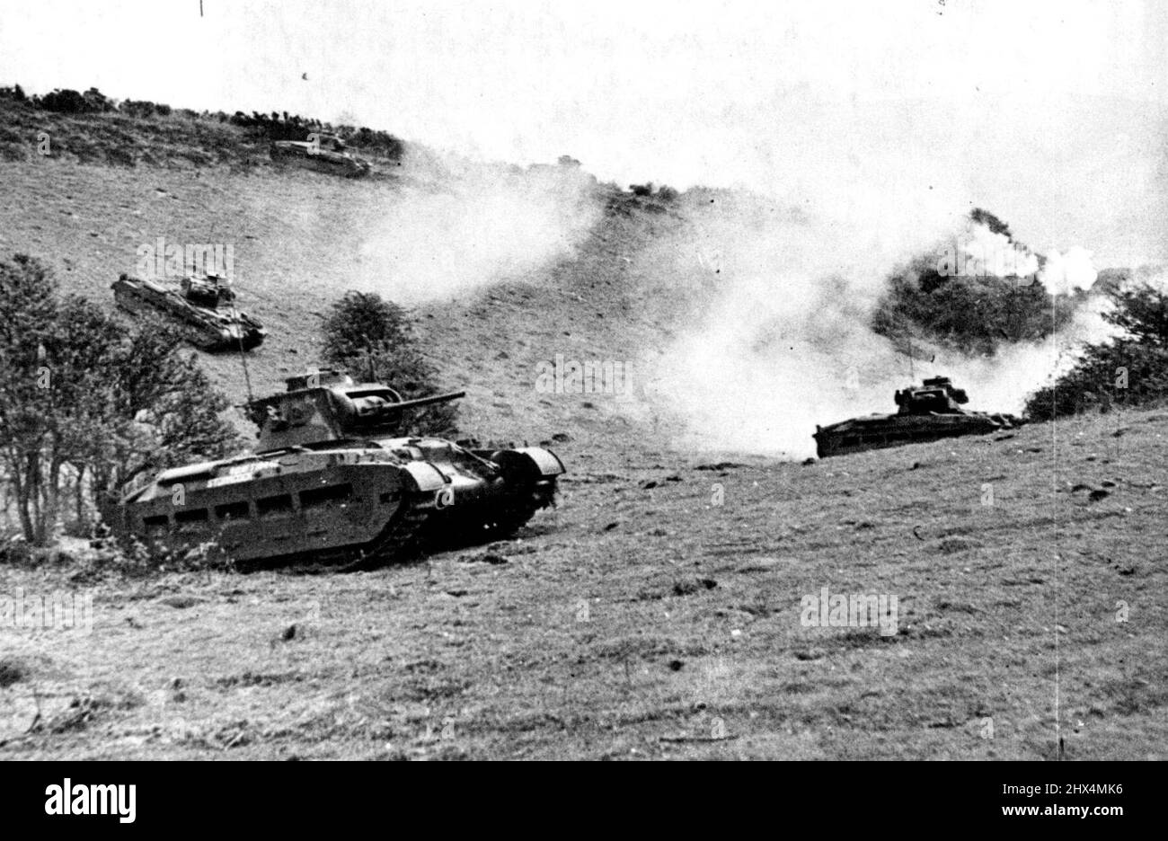 Carri armati in pioggia - carri armati che avanzano sopra paese collinare, sparando mentre vanno. La tendenza alla guerra moderna è verso la completa meccanizzazione e il carro armato è un elemento vitale dell'attrezzatura dell'esercito. L'attuale predecessore dell'ultima guerra, ed è un veicolo da combattimento veloce e manovrabile che può viaggiare su un Paese accidentato a una velocità sorprendente. Settembre 23, 1941. (Foto di British Official War Office Photo). Foto Stock