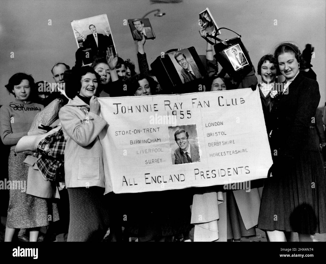 I tifosi di Johnny Ray attendono pazientemente all'Aeroporto di Londra -- Un gruppo dei membri del fan club di Johnny Ray 1955, tenendo in mano il fotografo del loro idolo, aspettando pazientemente all'Aeroporto di Londra per il suo arrivo oggi. Johnny Ray, il famoso crooner americano, è arrivato all'aeroporto di Londra questo pomeriggio. Diciotto presidenti del club dei fan di Johnnie Ray erano lì per incontrarlo all'aeroporto e torneranno al Dorchester Hotel con lui per una frizzante Lemonade. Marzo 31, 1955. (Foto di Fox Photos). Foto Stock