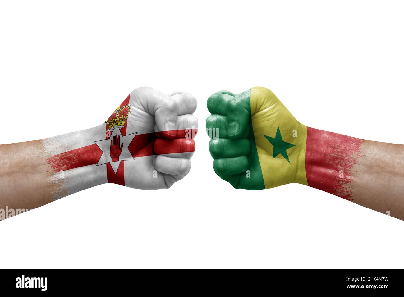 Due mani si pugno l'una all'altra su sfondo bianco. Le bandiere di paese dipinse i pugni, concetto di crisi di conflitto tra l'irlanda del Nord e il senegal Foto Stock