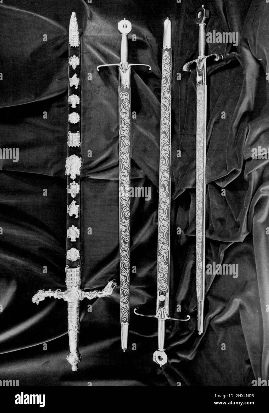 (Dall'alto verso il basso) la spada di stato la spada di giustizia spirituale la spada di giustizia temporale la spada di Misericordia (nota come Curtana) la spada di Stato è in spada a due mani, la lunghezza della lama è di 35 pollici. L'impugnatura è in metallo dorato, le traverse rappresentano il leone e l'unicorno. La scabbard è decorata con diamanti, rubini e smeraldi su disegni della Rosa, del Thistle e dello Shamrock. All'incoronazione il Peer che porta la spada di Stato la consegna al campione del Signore che, in cambio, gli dà la spada Jeweled. Dicembre 03, 1952. Foto Stock