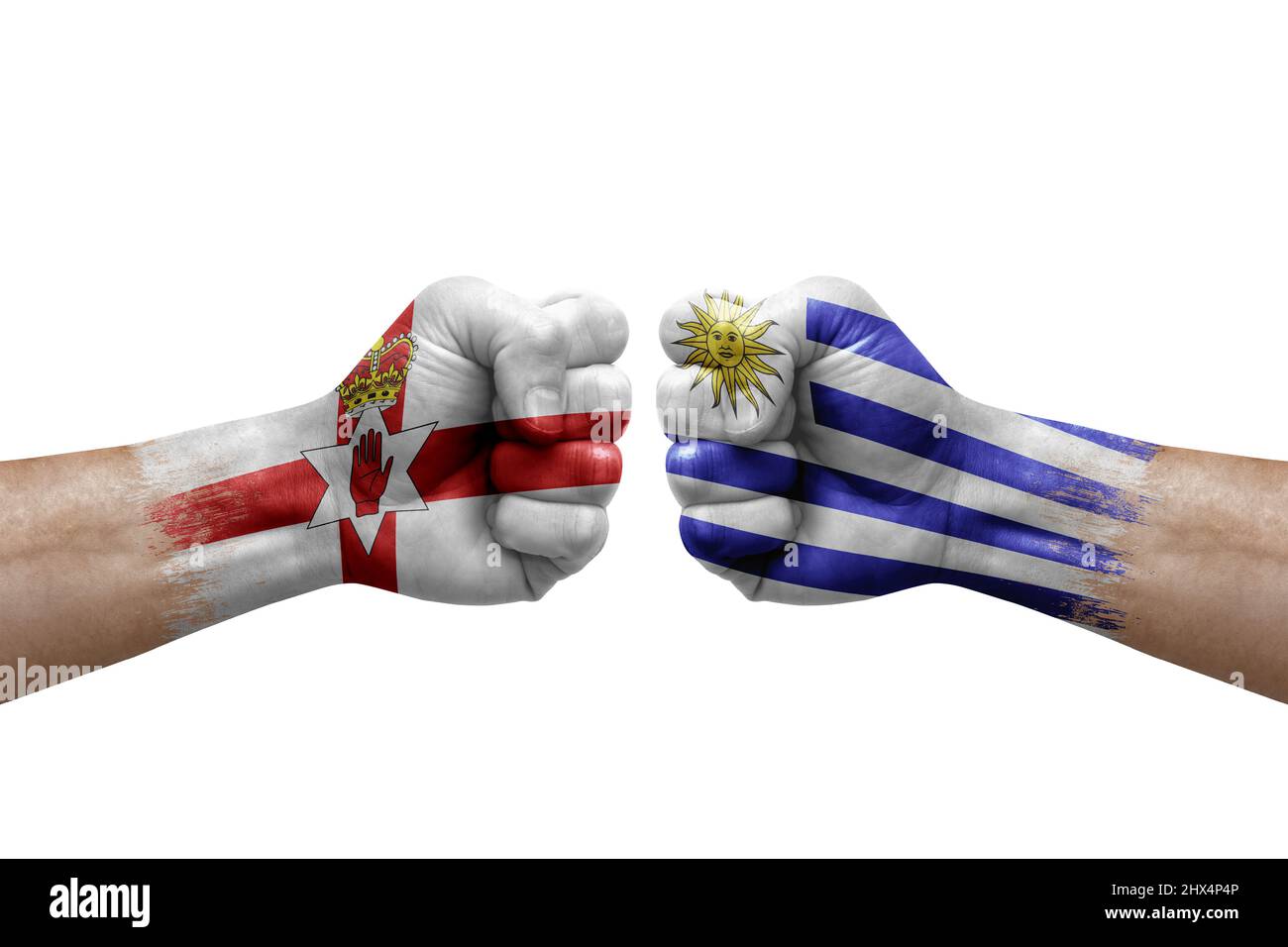 Due mani si pugno l'una all'altra su sfondo bianco. Bandiere di paese dipinte pugni, conflitto concetto di crisi tra l'irlanda del Nord e uruguay Foto Stock