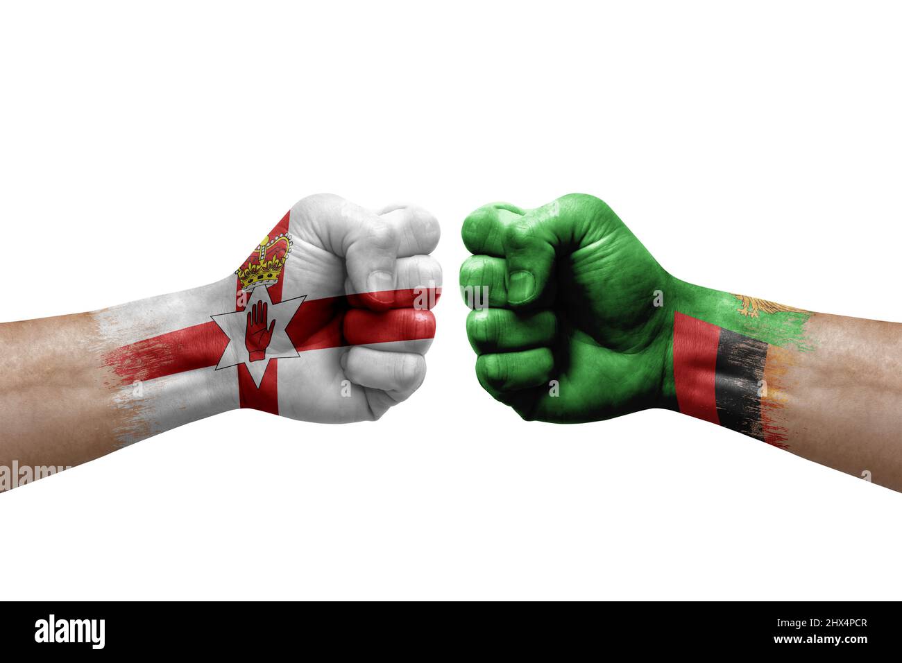 Due mani si pugno l'una all'altra su sfondo bianco. Bandiere di paese dipinte pugni, conflitto crisi concetto tra l'irlanda del Nord e zambia Foto Stock