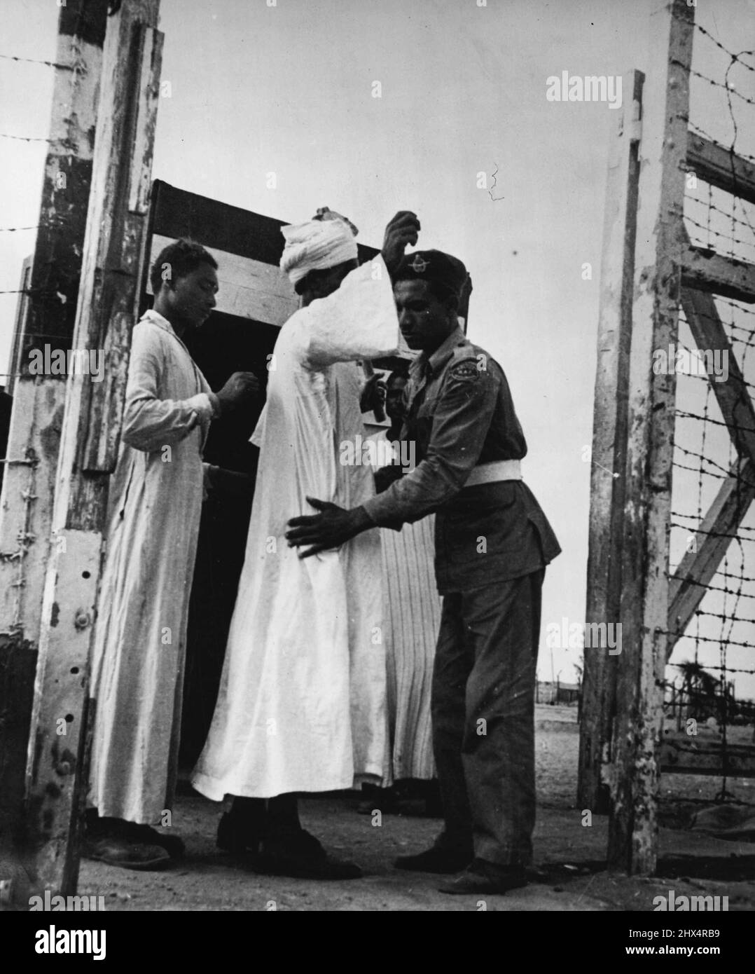 Fayid Camp: Roccaforte britannica nella zona del canale di Suez -- tutti gli Egiziani che entrano o escono sono scampati per le armi nascoste. Il filo spinato protegge la recinzione e i cancelli. Novembre 27, 1951. (Foto con fotocamera premere). Foto Stock
