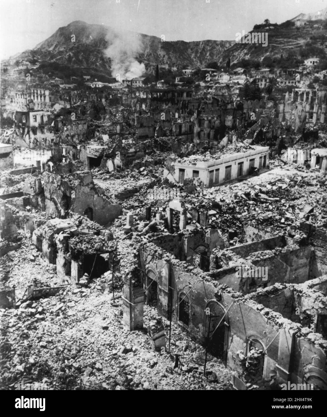 Cimitero di una città greca -- non una cosa vivente è visibile tra gli edifici macerati di Zante, una delle comunità greche dell'isola distrutte nella serie di terremoti della scorsa settimana. Il fumo sorge ancora da un edificio in fiamme in questa vista aerea a basso livello dal fotografo del personale addetto alla stampa Eddie Worth. Le navi navali di cinque nazioni oggi versavano in tonnellate di forniture di emergenza per i sopravvissuti affamati e senzatetto, mentre nuovi tremori scuotevano le devastate isole di Kefalinia, Ithaca e Zante. Agosto 17, 1953. (Foto di Eddie Worth, AP Wirephoto). Foto Stock