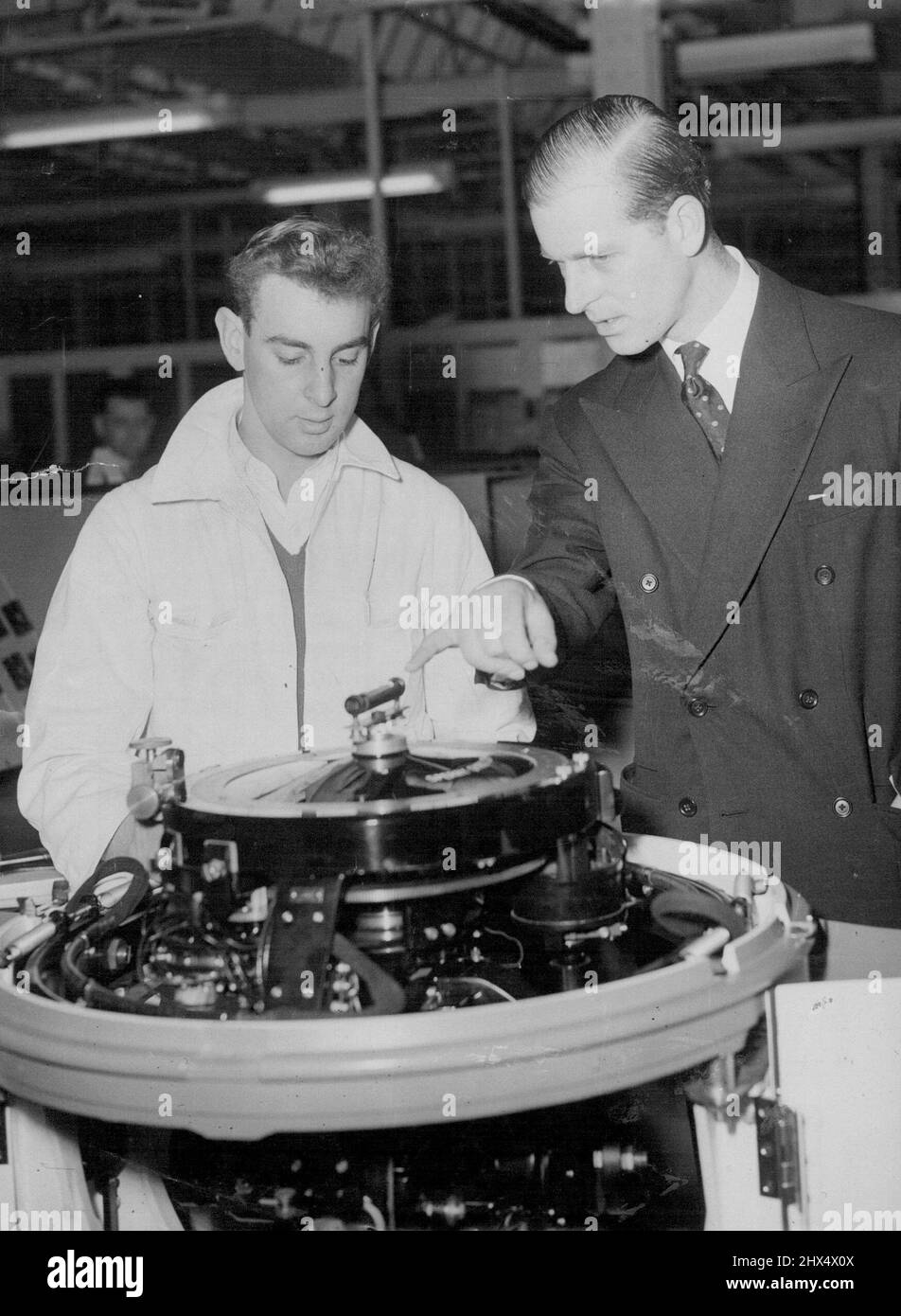 Duke studia Una Compass il Duca di Edimburgo parla di tecnica di navigazione con Derek Cheeseman di Birmingham, mentre studia una bussola giroscopica marina presso la Sperry Gyrescope Company's Works at Great West Road, Brentford, Middlesex, oggi. Il Duca, che è egli stesso un marinaio e pilota d'aria, ha mostrato grande interesse per quegli strumenti di navigazione che mantengono le navi e gli aerei stasi giorno. Un appassionato marinaio e un aviatore, il Duca discute i punti più fini di una bussola giroscopica marina con un ingegnere in una fabbrica essere ispezionato. Febbraio 24, 1953. (Foto di Reuterphoto). Foto Stock