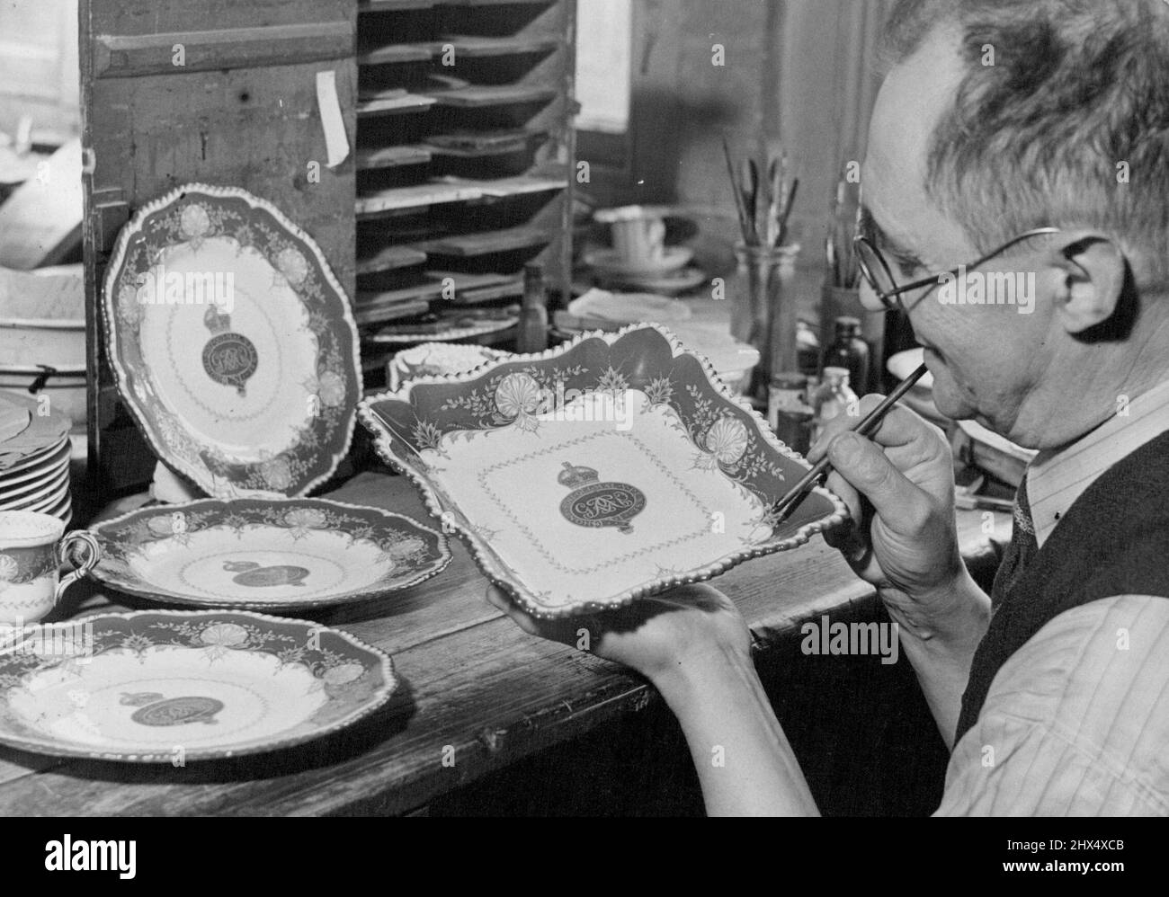 Guardie presenti alla Principessa -- un artista che prepara un piatto di frutta come parte dei campioni di esposizione a St. James's Palace. Badge sulla Cina nella foto è quello delle Guardie Grenadier. Un dessert imperiale rosso e oro, il servizio è stato ordinato dalla Brigata delle Guardie come un sarchiatore presente per la principessa Elisabetta, ed è stato fatto a Worcester dalla Royal Porcellane Company. È uno dei quattro servizi della cina che sono fatti come regali di nozze per la brigata delle guardie (2) la città di Worcester e la società worshipful dei carpenters, nessuno di cui sarà pronto fino a quasi un anno dopo il matrimonio Foto Stock