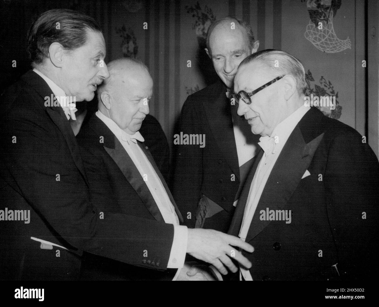 Il Sig. Gifford incontra il Sig. Bevin tra i pellegrini -- il Sig. Walter Gifford (secondo da sinistra) in un gruppo animato composto dal Sig. Ernest Bevin, il Segretario degli Affari Esteri; Sir Campbell Stuart (a sinistra), Vice-Presidente dei pellegrini; e Lord Halifax, il Presidente dei pellegrini (dietro) alla Savoia fino a notte. Walter Gifford, il nuovo ambasciatore degli Stati Uniti a Londra, ha adempiuto il suo primo impegno pubblico dal suo arrivo quando a notte (martedì) i pellegrini della Gran Bretagna hanno dato la tradizionale cena di benvenuto per l'ambasciatore al Savoy Hotel, Londra. Gennaio 9, 1951. (Foto di Reuterphoto). Foto Stock