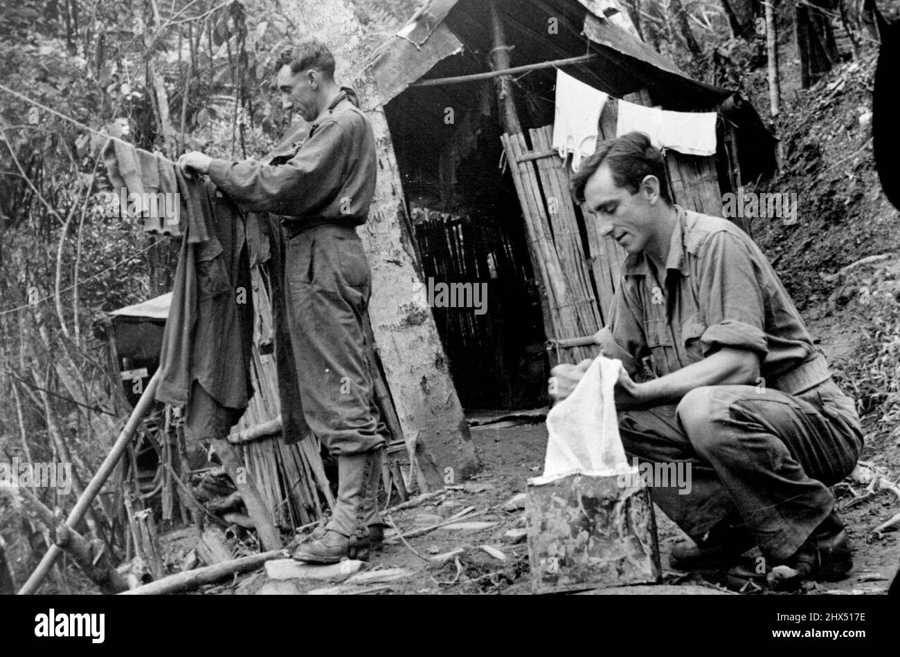 Campagna di Mubo della Nuova Guinea. Giorno di lavaggio da qualche parte vicino a Mubo sul lato di una pendenza ripida. Il sergente Les Almond di Easternwick, Victoria, e il caporale Frank Milroy di St. Kilda , fuori dalla loro giungla capanna. Settembre 7, 1943. (Dipartimento delle informazioni, Commonwealth of Australia). Foto Stock