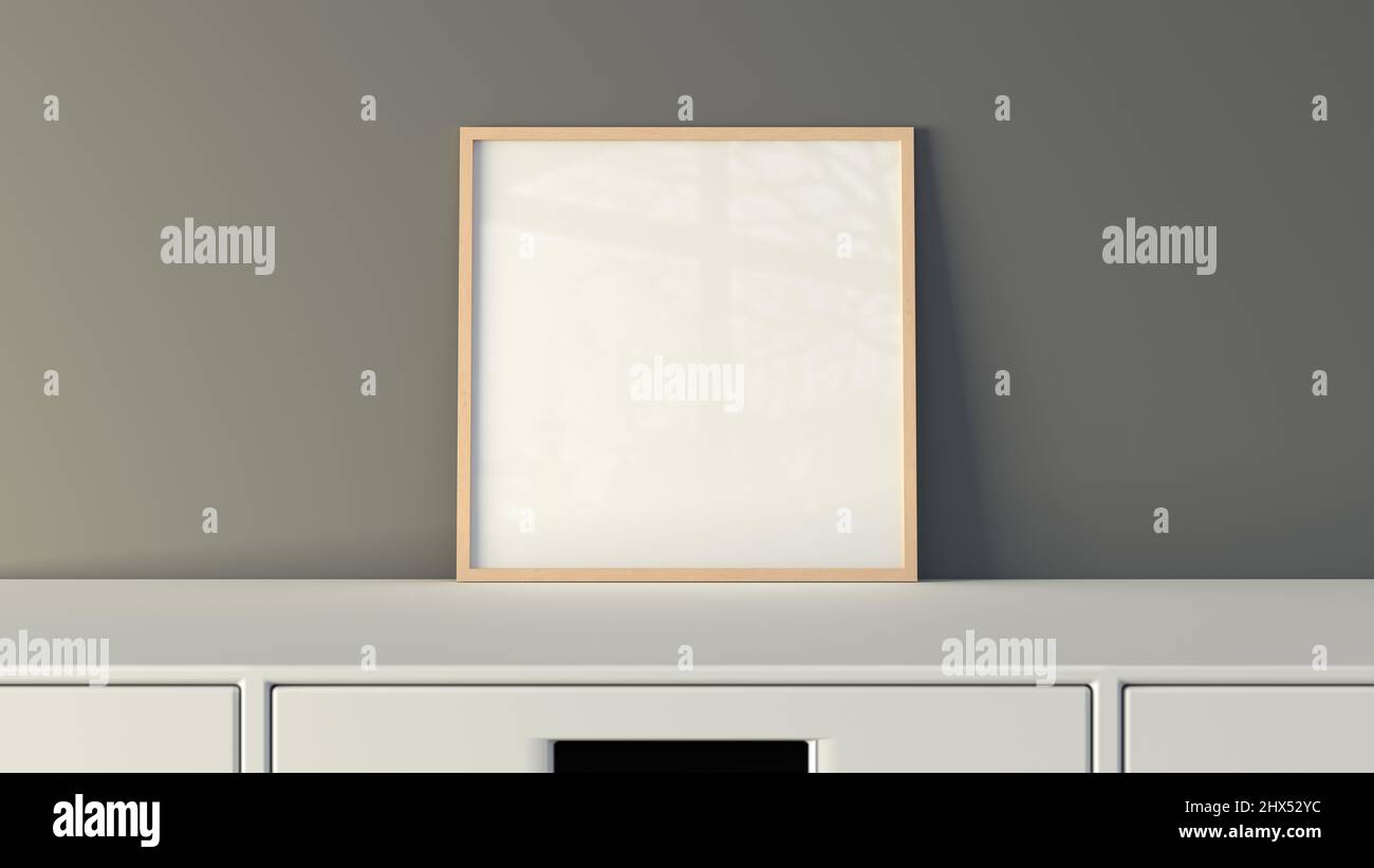 Poster con cornice quadrata sul tavolo bianco con parete grigia sullo sfondo Foto Stock