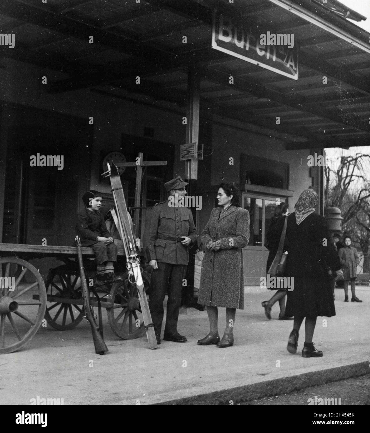 Un soldato cittadino svizzero (4) di Set of II - Richard Scheurer e sua moglie hanno mostrato alla stazione ferroviaria di Buren mentre attendono il treno che lo porterà nella zona di manovra. Il figlio di Scheurer custodisce l'attrezzatura militare. Aprile 2, 1948. (Foto di Acme). Foto Stock