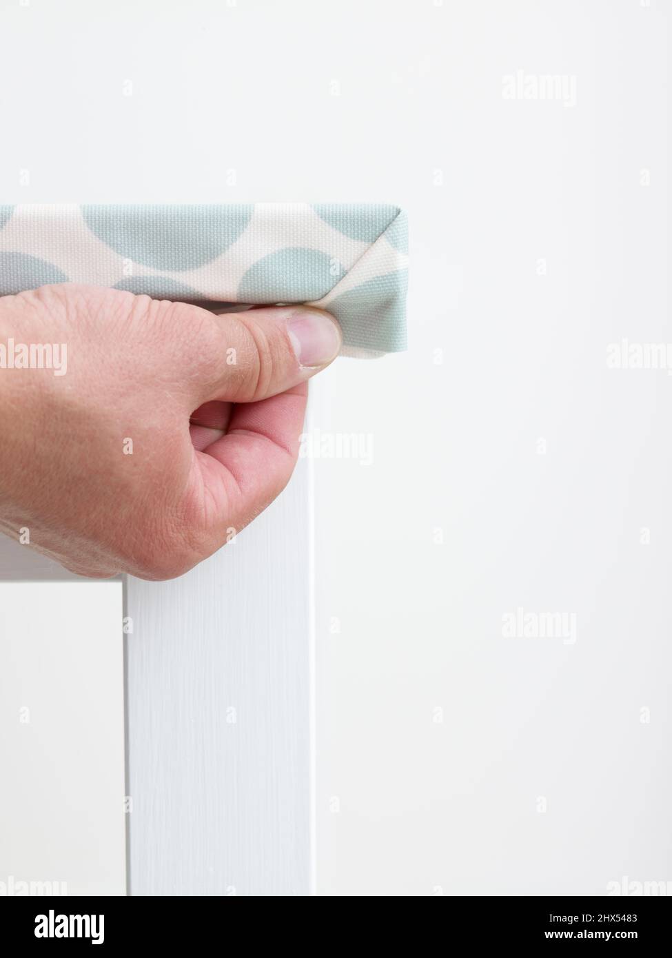 Coprendo il tavolo da cucina con tela ad olio, piegando gli angoli Foto Stock