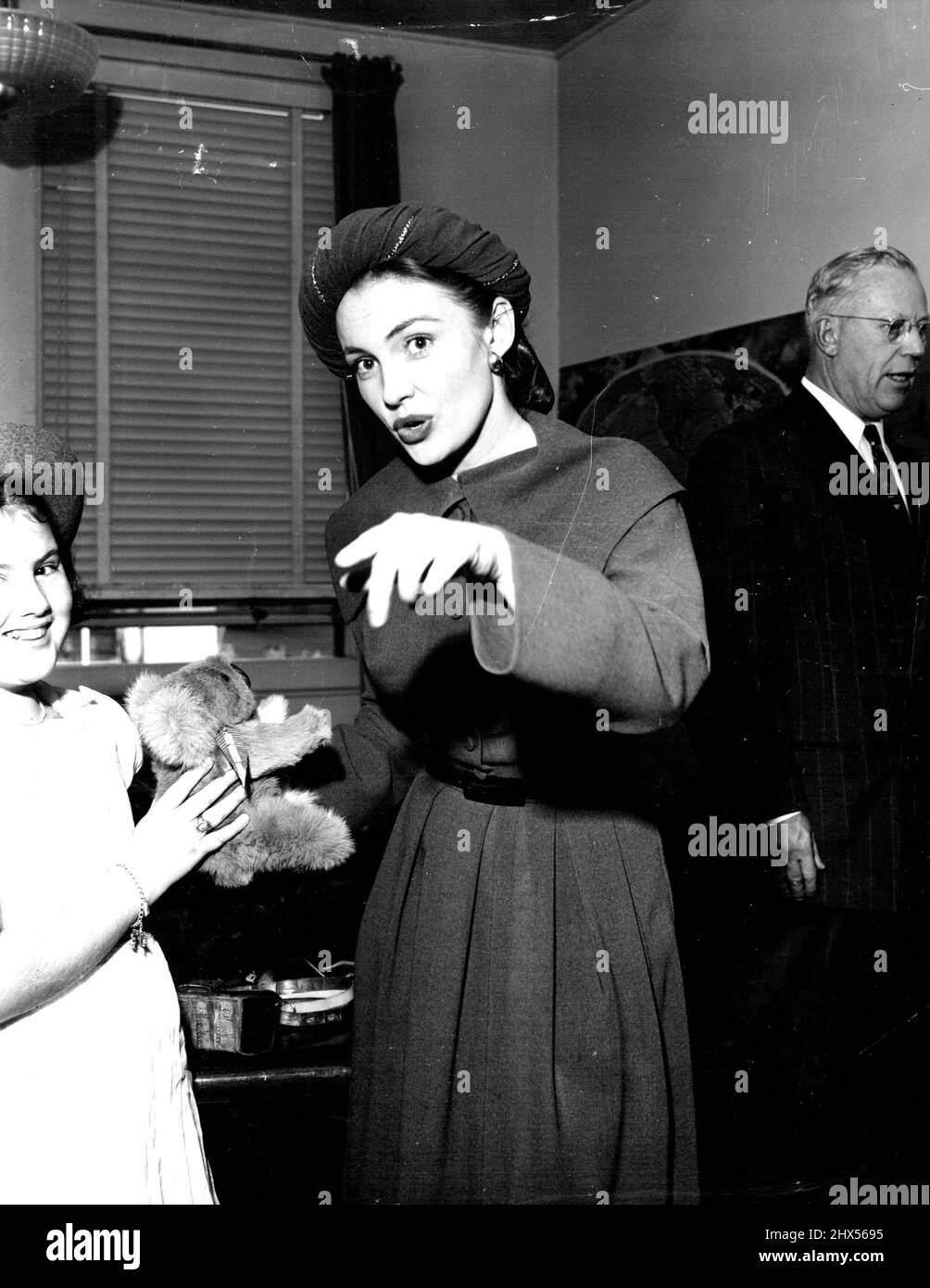 Un koala giocattolo volò alla recente Fiera dell'aria di San Francisco da B.C.P.A. è presentato dalla figlia del gestore dell'aeroporto a Hollywood Joan Leslie. Earl Warren, Governatore della California, si trova sullo sfondo. Novembre 24, 1949. Foto Stock