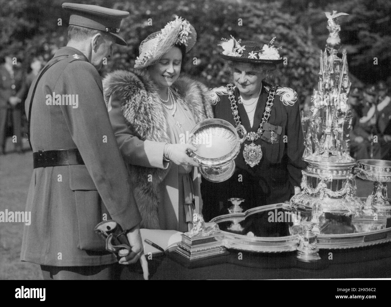 La regina ispeziona il reggimento di Manchester -- il famoso vecchio pezzo centrale in argento, fatto da trofei di battaglia fusi, che è stato in possesso del reggimento since1881. Sua Maestà, a nome del reggimento, la consegnò alla città di Manchester attraverso il sindaco di Lord, Alderman, signora Mary. L. Kingsmill Jones.H.M. La regina pagò la sua visita come colonnello-in-capo del reggimento di Manchester martedì, quando ispezionò 500 ufficiali e uomini e 600 vecchi compagni al deposito dell'unità a Hunham Park, vicino Manchester. La visita è stata la fase iniziale del tour di due giorni di sua Maestà a Cheshire e Lancashi Foto Stock