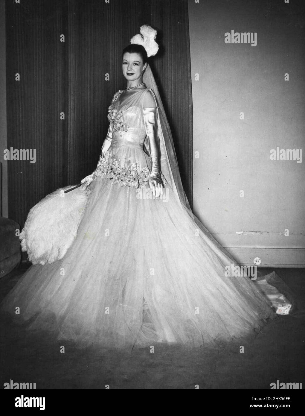 Court Presentation Downs for U.S. Symphony of Fashion -- The Debutante Court Presentation Gown Designed by Norman Hartnell. Migliaia di donne americane che visiteranno la Sinfonia della Moda a St. Louis, Misseuri, nel mese di febbraio, vedranno due presentazioni tradizionali della Corte. Camici, completi di piume, treno e ventilatore. Sebbene dal ***** non sia stato tenuto alcun tribunale Prima della guerra, i couturiers londinesi Worth e Hartnell stanno entrambi facendo camici speciali, che-spogliato dei loro ritagli di Buckingham Palace, faranno gli abiti per ogni occasione importante. Gli abiti fanno parte di un trusseau che è il 'Big di Londra Foto Stock