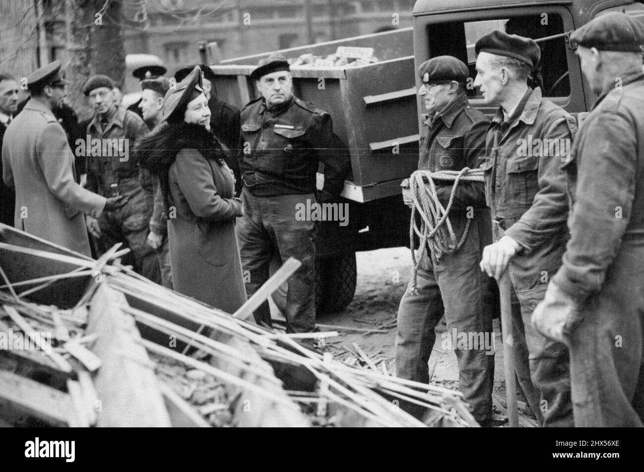 Il Re e la Regina visitano alcune delle aree bombardate di Londra - la Regina che parla con le squadre di salvataggio in una zona blitzed; il Re sta parlando con altri lavoratori di soccorso sulla sinistra. Febbraio 25, 1944. Foto Stock