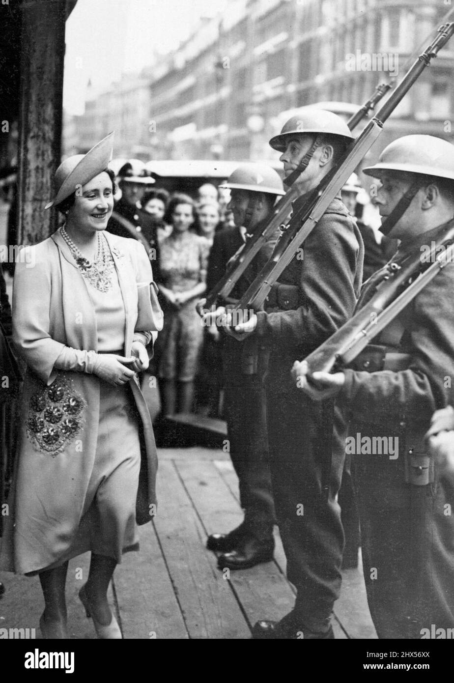 La Regina nella Città - la Regina che arriva attraverso una guardia d'onore delle truppe. H.M. la Regina ha visitato oggi la sede dei telefoni dell'ufficio postale, Faraday House, Queen Victoria Street, Londra, E.C. dove ha fatto un tour di ispezione. Luglio 10, 1940. (Foto di Topical Press). Foto Stock