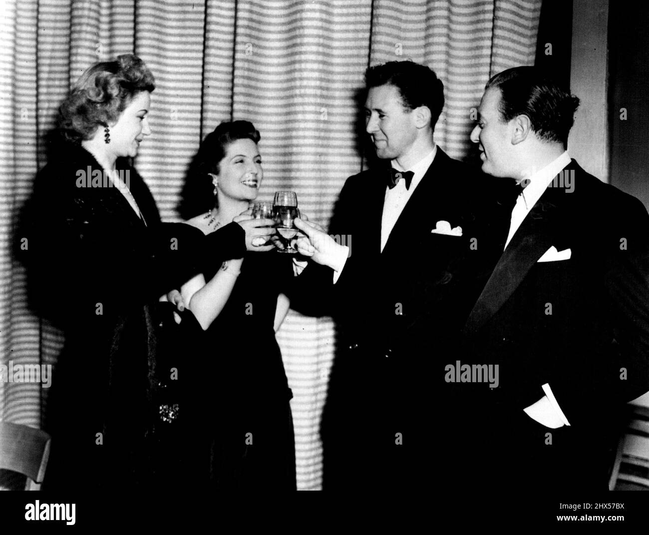 Anthony Quayle, direttore di 35 anni dello Shakespeare Memorial Theatre a Stratford-upon-Avon, che alla fine dell'anno sarà a capo dell'azienda che visiterà l'Australasia, è visto in questa fotografia informale con sua moglie, la star del palcoscenico Dorothy Hyson. Bere le loro guarighe sono la star del cinema e del palcoscenico Margaret Leighton (a sinistra) e il marito di quest'ultimo, l'editore Max Reinhart. Luglio 18, 1949. Foto Stock