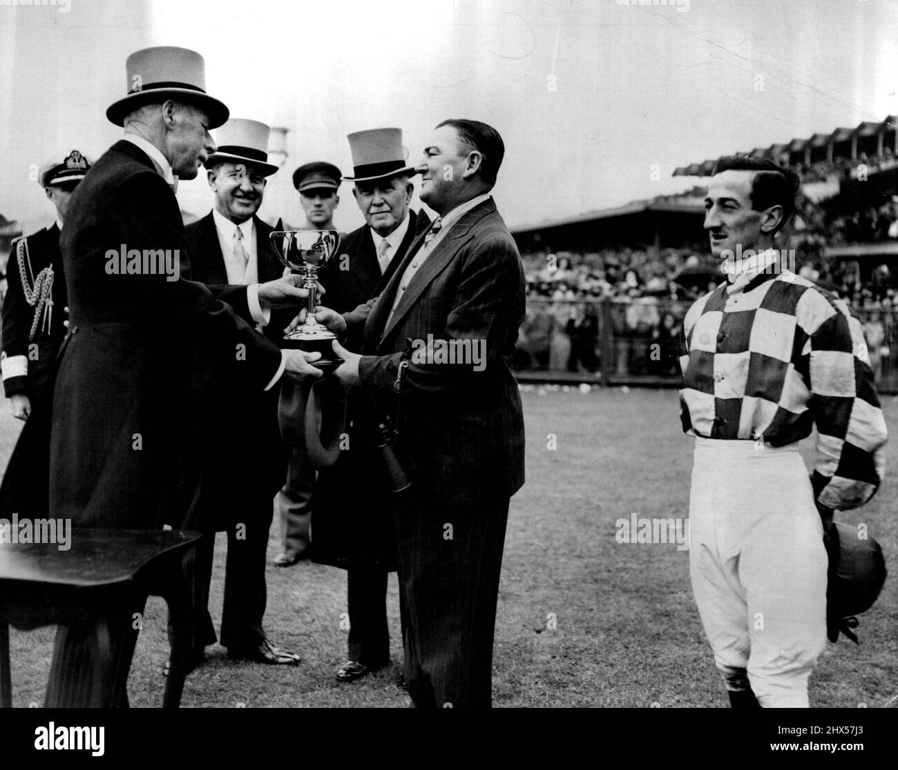 Presentazione della Melb Cup da parte del governatore di Vic Sir Winston Dugan. La cerimonia è stata eseguita da Sir Winston a ***** di ***** Il generale Gov M. McKell perché Sir Winston imparando per l'Inghilterra. Guardando un po 'come se davvero non dovrebbe essere lì, Purtell si alza durante la presentazione del 1947 ***** Novembre 6, 1947. Foto Stock