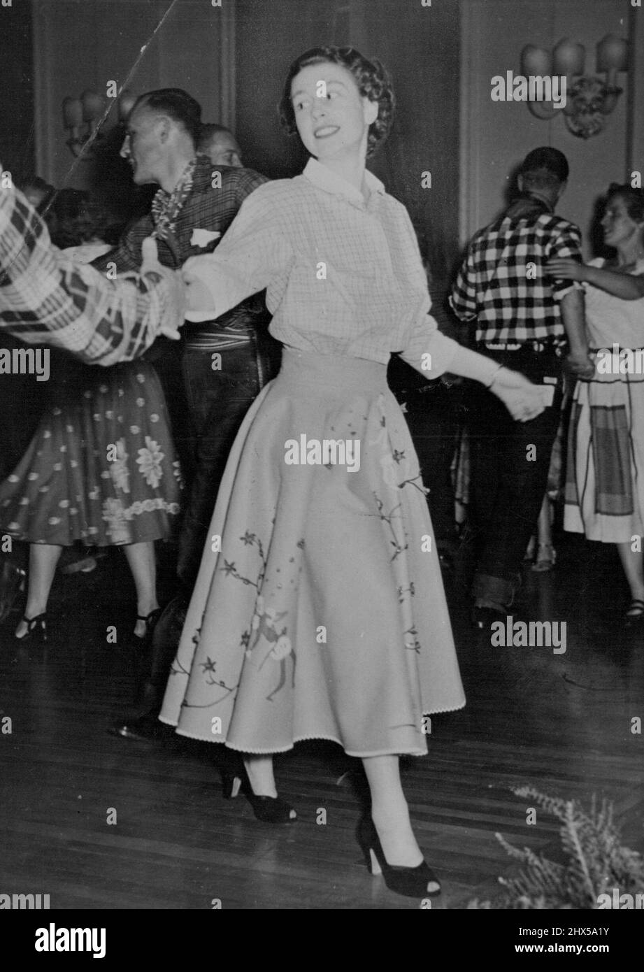 La principessa va gay a Ottawa Barn-Dance -- Un partner di check-shirted oscilla il vestito gaily e felicemente sorridente Princess round durante il fienile-dance a Rideau Hall alle istruzioni gridate del 'chiamante'. L'aspetto ufficiale del tour reale di Ganada è stato rilassato venerdì 12th ottobre, quando la principessa Elisabetta e il duca di Edimburgo hanno partecipato a una tradizionale danza di fienile tenuto presso la Rideiau Hall. Ottawa, sede del Governatore Generale. Visconte Alexander. La coppia reale insieme con il resto degli ospiti- indossava il costume accettato di fienile-danza, la principessa a gonna dirndl e la blusa contadina th Foto Stock