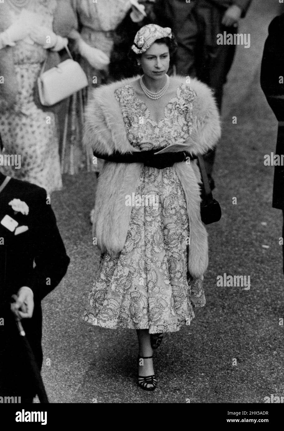 The Queen's Ascot Fashion for Ladies Day -- H.M. la Regina ha visto camminare al Paddock ad Ascot questo pomeriggio. Per il giorno delle Ladles, sua Maestà era vestita in modo incantevole con un abito in pizzo bianco filmy ricamato in pinne blu navy treccia. La sua piccola testa abbracciava il cappello inclinabile in avanti, era da abbinare e la regina aveva una pelliccia intorno alle spalle come protezione contro le brezze fredde. Due caratteristiche eccezionali del suo ensemble sono state l'attraente scollo a V smerlato del suo abito e l'impugnatura extra lunga per la sua borsa. Oggi è stata la Giornata delle Signore ad Ascot - il terzo giorno dell'incontro e diversi membri del Foto Stock