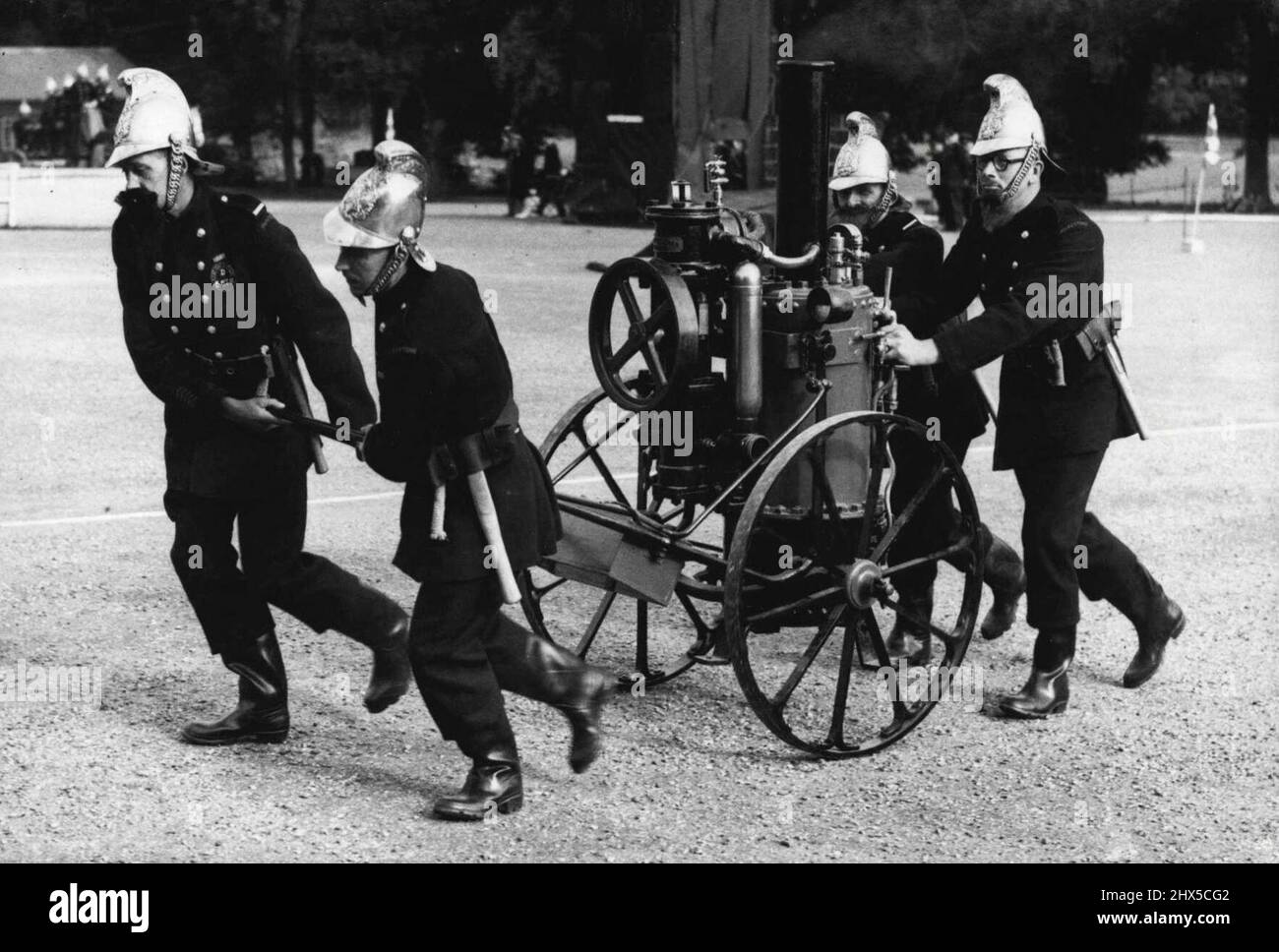 Vigili del fuoco del vecchio - lotta al fuoco come un tempo era un'immagine divertente durante una esposizione dei vigili del fuoco del Kent di antichi e moderni combattimenti del fuoco tenuti a Maidstone, Kent. Un'antica pompa del vapore che doveva essere maneggiata dai vigili del fuoco alla scena dell'epidemia. Ottobre 3, 1949. (Foto di Sport & General Press Agency Limited). Foto Stock