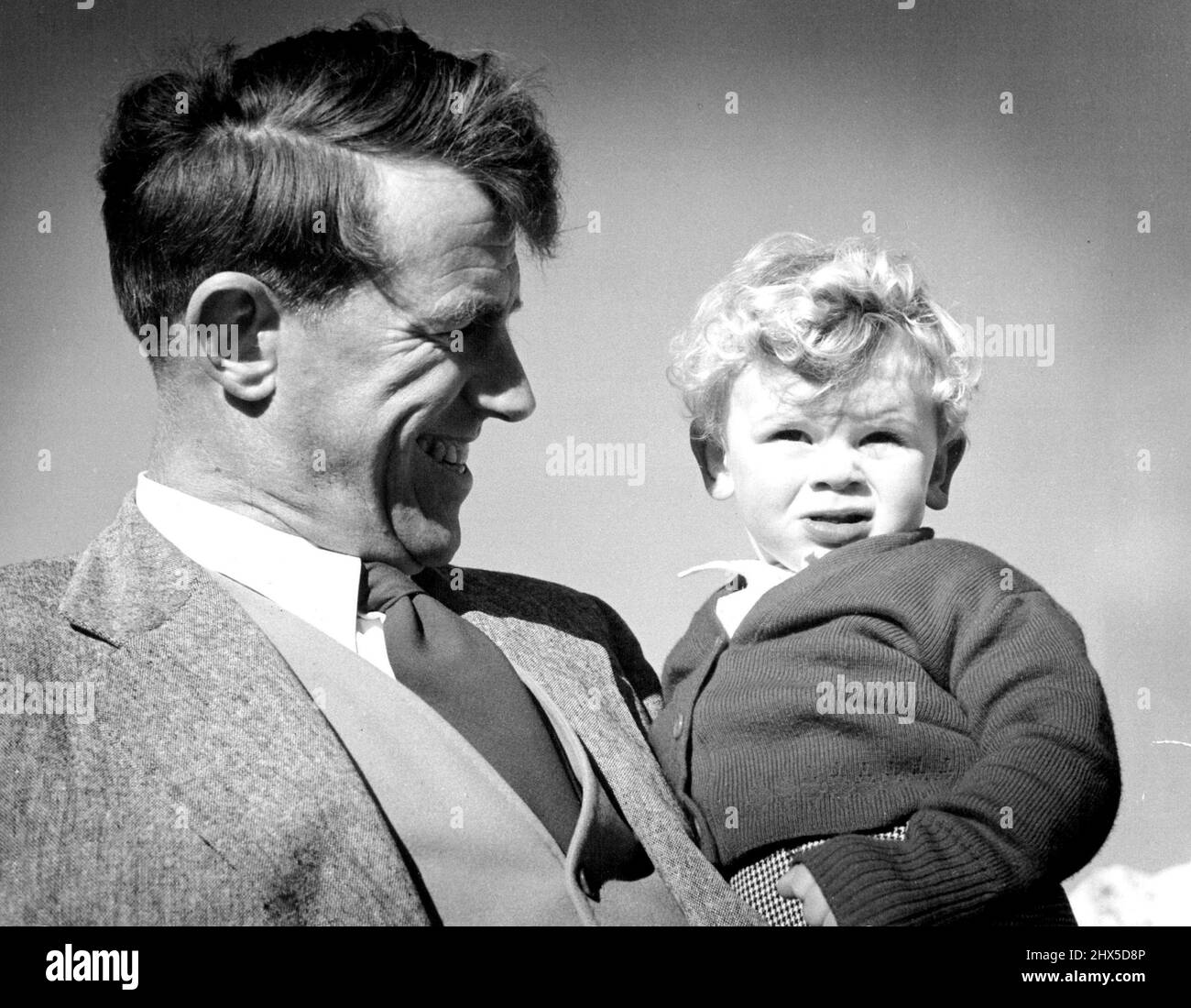Sir Edmund Hillary, leader della spedizione in Antartide della Nuova Zelanda, si pone con orgoglio con suo figlio Pietro. Agosto 28, 1953. Foto Stock
