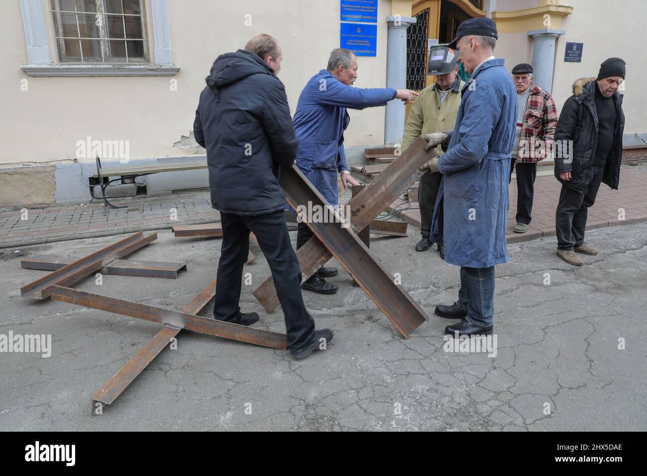 La gente fa gli ostacoli anti-serbatoio cechi hedgehog in Lviv in mezzo all'invasione russa dell'Ucraina. Foto Stock