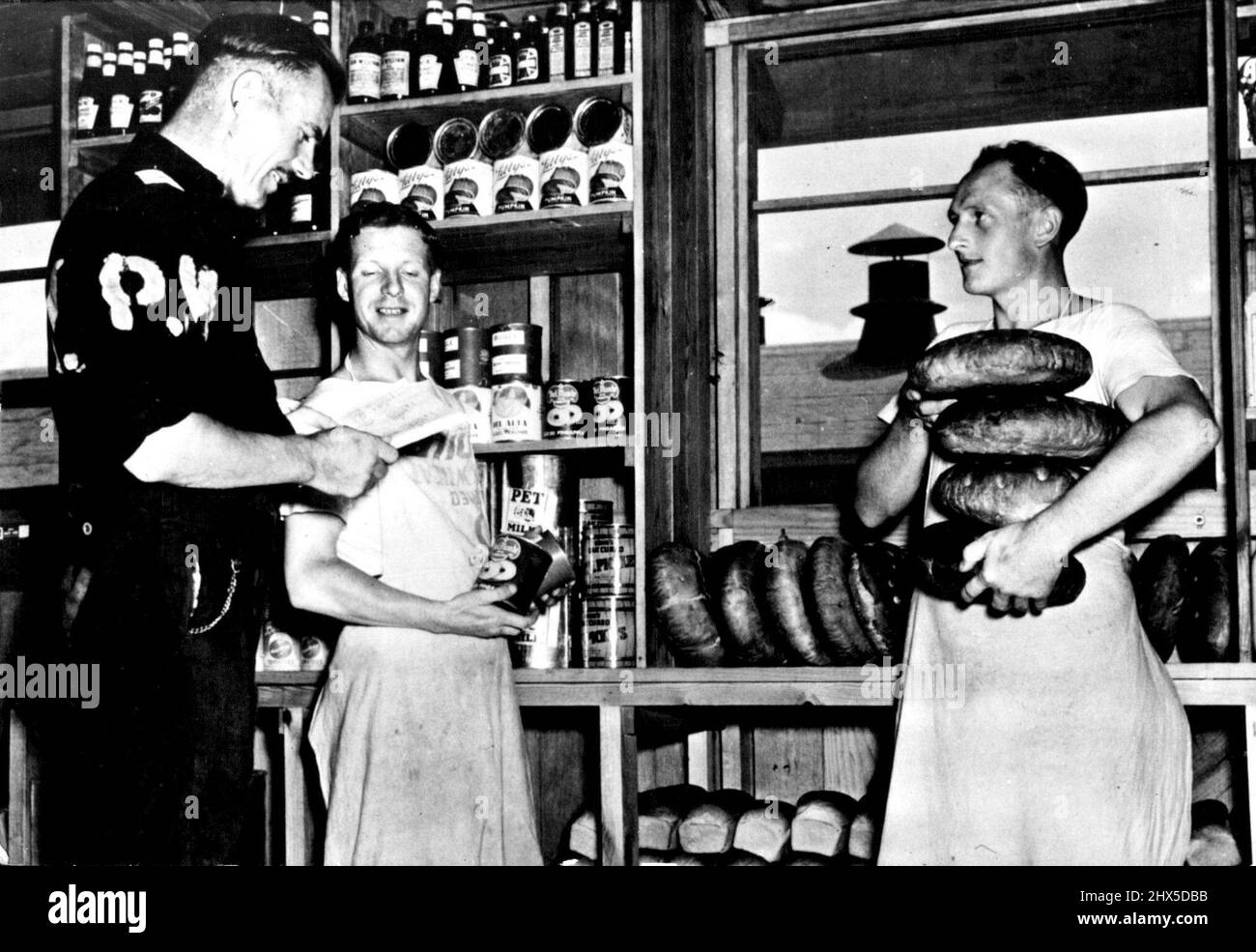 Prigionieri dell'asse negli Stati Uniti un sergente del mess tedesco (a sinistra) controlla i rifornimenti nella sala del mess dei prigionieri dell'asse di guerra ad un campo negli Stati Uniti gli uomini sono dati l'alloggiamento ed il cibo paragonabili a quello fornito per i soldati dell'esercito degli Stati Uniti. I menu tipici serviti al campo includono frutta o succo di frutta, cereali cotti, uova strapazzate, toast e caffè per colazione; stufato di manzo o vitello per cena; e salumi di carne, insalata di patate, caffè o tè e budino di pane per cena. Agosto 29, 1950. (Foto di U.S. Office of War Information Picture). Foto Stock