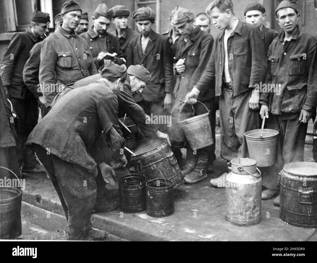 Gli americani liberano i soldati alleati imprigionati dai nazisti in Francia - nuovi soldati russi liberati in attesa di zuppa, mado da loro cuochi provenienti da forniture statunitensi. Quando il terzo esercito degli Stati Uniti, comandato dal tenente generale George S. Patton, Jr., liberò Saarguemines, Francia, dicembre 12, 1944, trovarono un campo di prigionia tedesco dove furono incarcerati soldati russi, serbi, polacchi e italiani, condizioni spaventose. Gli uomini sono stati quartati in stanze di sette per otto piedi. Pochi avevano stufe in loro. Sono stati utilizzati tre tipi di cuccette. Ogni detenuto aveva solo uno senza facilitazioni sanitarie. Foto Stock