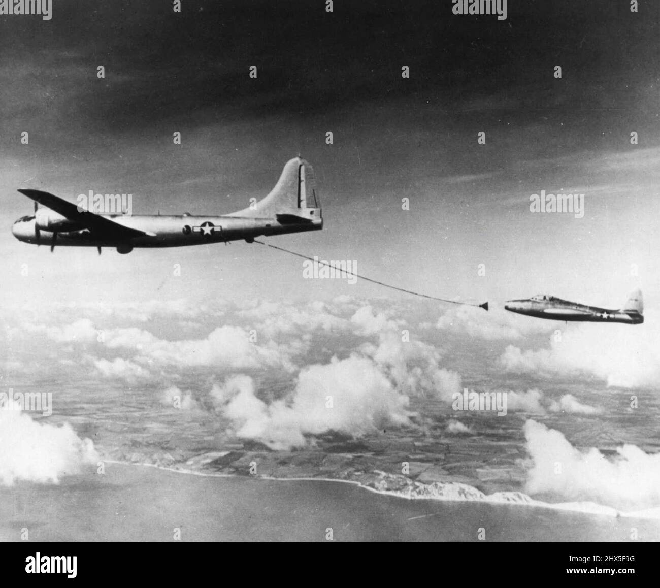 Come i jet si rifanno sul volo Atlantico -- Un B-29 Tanker aereo con un tubo flessibile di carburante che esce fuori dietro esso è in battuta per fare contatto con un F-84 jet fighter nella pratica l'operazione di rifornimento che è usato sull'odierno volo Londra-a-New York da due getti monomotore. Il jet plane TE qui è uno dei due che fanno il volo. Durante il funzionamento, il pilota a getto lancia un piccolo braccio che si estende dalla sua ala nell'ugello a forma di imbuto all'estremità del tubo flessibile della cisterna. Settembre 22, 1950. (Foto di AP Wirephoto). Foto Stock