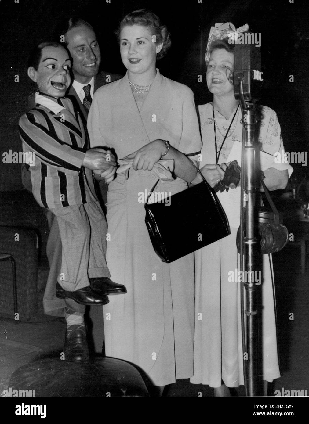 Happy You're 'in Town to-Night': Archie dimostra che non è così muto come egli estende un eloquente benvenuto a 'Miss Australia', 19 anni di miele bionda Sydney modello Miss Margaret Hughes negli studi presso Broadcasting House, Londra, quando è apparsa sulla caratteristica 'in Town to-night' questa sera (Sabato). Archie è manipolato dal suo maestro, il ventriloquista Peter Brough. Con Miss Hughes è il suo accompagnatore, la signora Joyce Snelling. Miss Australia è a Londra nel giro del mondo che ha vinto come premio in un concorso. Giugno 3, 1950. (Foto di Reuterphoto). Foto Stock