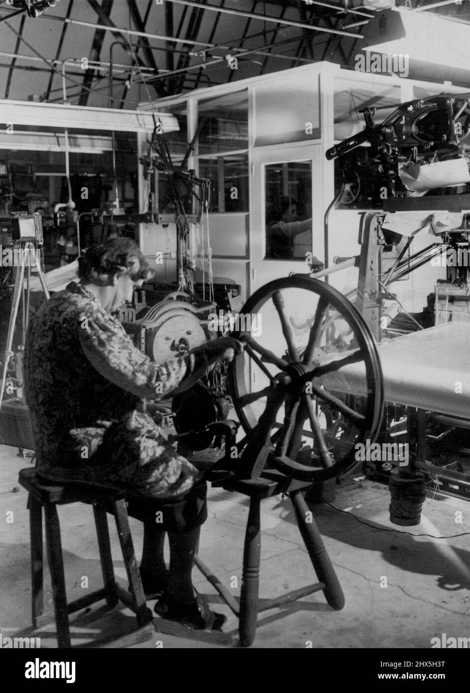 Facendo ***** Per l'incoronazione della Regina ***** . Forewoman Sig.ra Ivy ***** aziona una mano ***** Winder che è in uso da oltre 100 anni come lei aiuta nella fabbricazione del sating che sarà linea la regina Coronation Robe. In background può essere visto 17-year-old tessitore Miss Gwen Curtis, anche impegnato nel fare il satin, alla ditta di Stephen Walters qui. Ventuno metri di questo materiale saranno necessari per il rivestimento del Robe della Regina, ma l'azienda sta facendo circa 60 metri in 'caso di incidenti'. Dicembre 3, 1952. Foto Stock