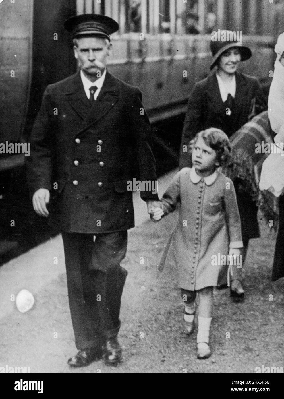 La Principessa Elizabeth Future Queen of England visita la Scozia poco prima del suo nono compleanno. La Principessa Elisabetta, circa due mesi prima del suo nono compleanno, si presenta di pari passo con il Maestro di stazione di Glamis Station, di Strathmore, padre della Regina Elisabetta. Novembre 1, 1945. Foto Stock