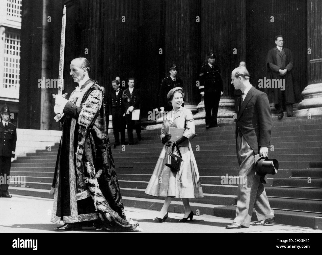 Un sorriso per il duca... La Regina sorride al Duca di Edimburgo, mentre, guidato dal Signore Sindaco di Londra, Sir Rupert de la Bere, che porta la spada tradizionale, lasciano la Cattedrale di San Paolo seguendo il Servizio di ringraziamento dell'Incoronazione. Giugno 9, 1953. United Press Photo). Foto Stock