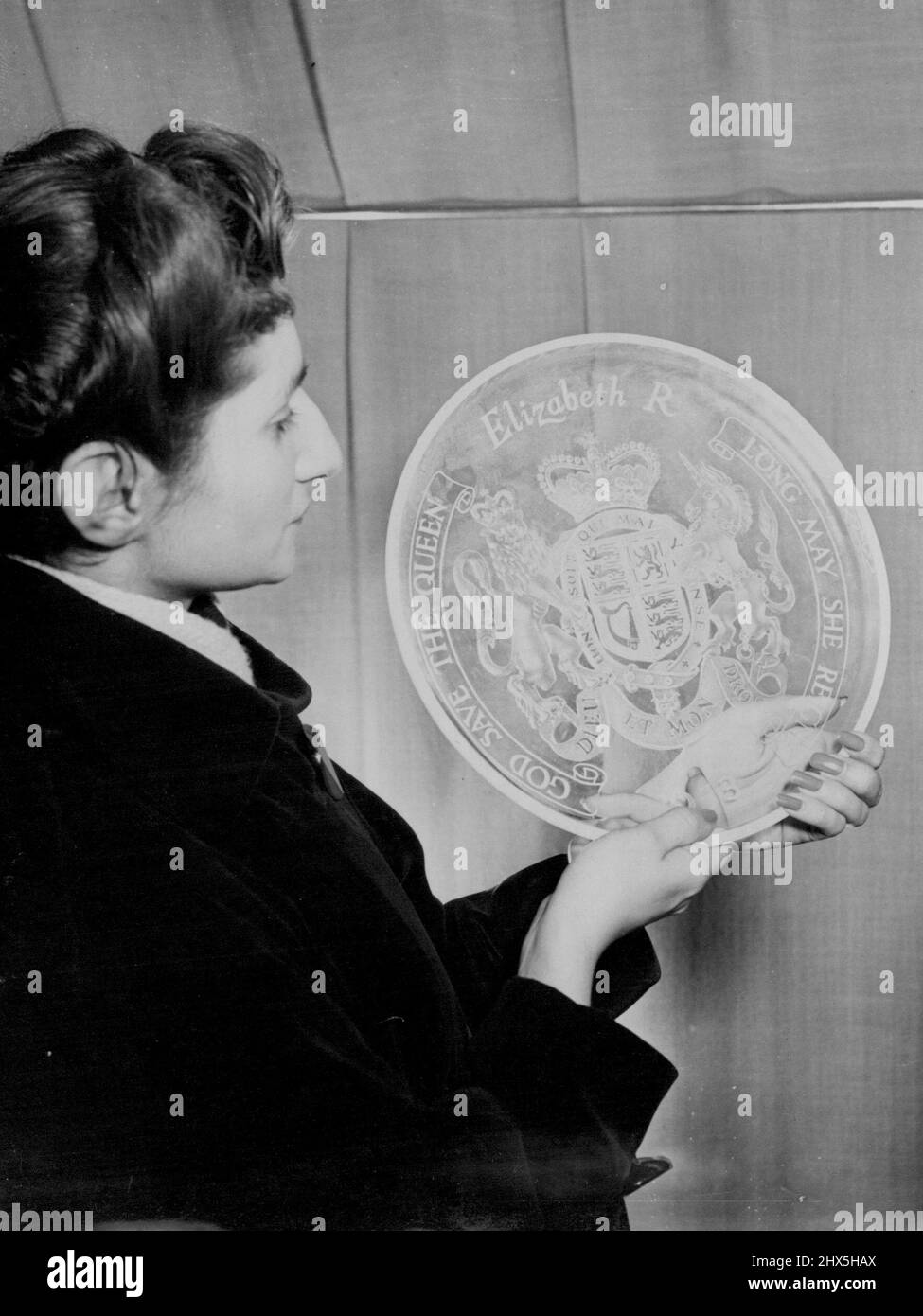 Anteprima dei souvenir dell'incoronazione per gli acquirenti. Phyllis Albuqueque di Hove, Sussex, esaminando una lastra commemorativa di vetro sabbiato in anteprima della mostra al giorno (Lunedi). Il piatto, tra i più costosi souvenir in mostra, costerà circa £25. Una collezione di quasi mille souvenir dell'incoronazione scelti dai Comitati souvenir dell'incoronazione del Consiglio del disegno industriale ***** Da mostrare al pubblico per la prima volta in una mostra che si apre al Centro del tè, Regent ***** , Londra, domani (Martedì) fino a Mach 13. Febbraio 23, 1953. (Foto di Reuterphoto). Foto Stock