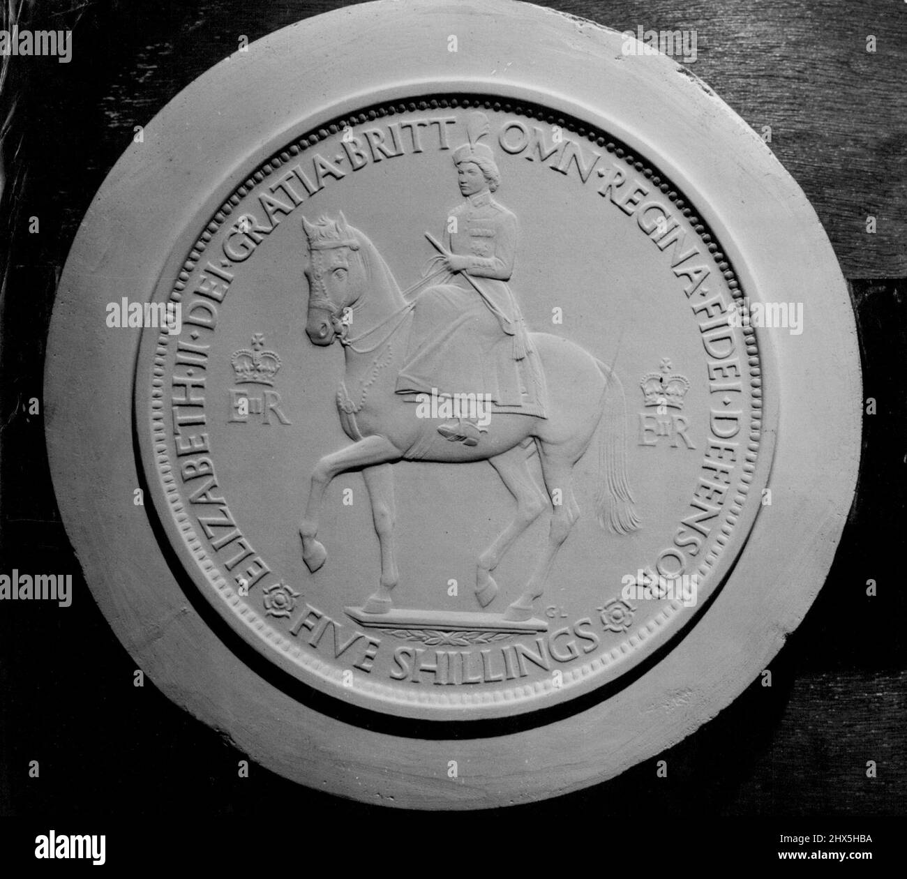 Design per Coronation pezzo in corona: Effige equestre della regina. Il calco in gesso raffigurato qui mostra il disegno approvato per l'obverse del pezzo Coronation Commemorative Crown che sarà pubblicato nel 1953. Il progetto, di Gilbert Ladward, R.A., è un'effigie equestre a tre quarti di vista di sua Maestà la Regina nell'uniforme del colonnello-in-Capo, le Guardie Grenadier. Il pezzo sarà colpito in cupronickel, e sarà rilasciato al pubblico attraverso le banche al costo di 5s64., escluso di affrancatura e registrazione. Dicembre 18, 1952. (Foto di Reuterphoto). Foto Stock