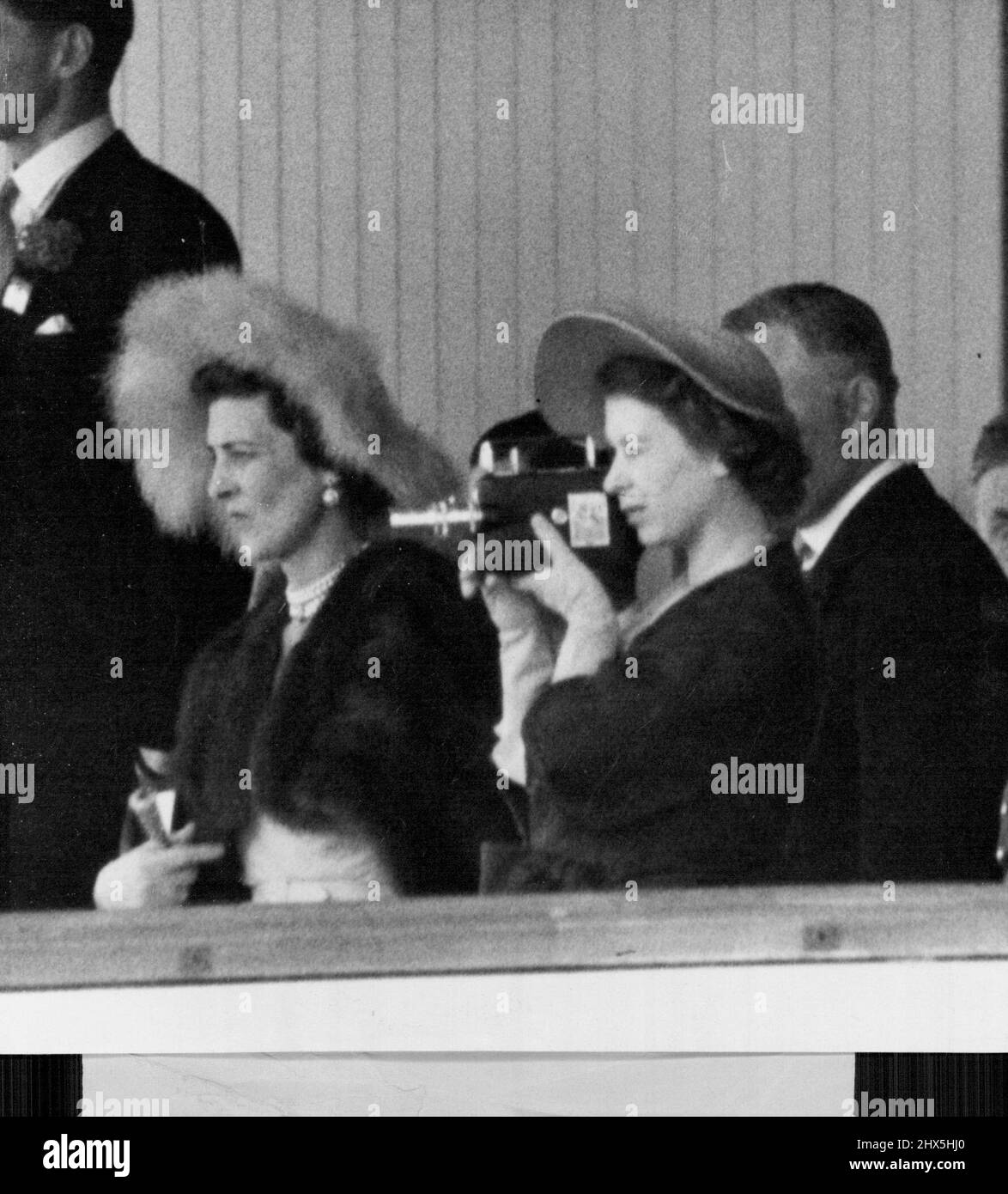 Il principe Elisabetta fotografa la processione dell'Ascot -- la principessa Elisabetta, dalla scatola reale, fa una foto cine della processione reale ad Ascot oggi. La pioggia che ieri ha bagnato il tappeto erboso Ascot, ha portato una carica dell'ultimo minuto nella giornata della Coppa d'oro della famiglia reale gioca a-giorno (Giovedi). Invece di guidare attraverso le Porte d'Oro, secondo la consuetudine, il Re e la Regina e altri membri del partito reale cambiarono da auto a pullman a Duke's Drive, per la processione tradizionale. Giugno 15, 1950. Foto Stock