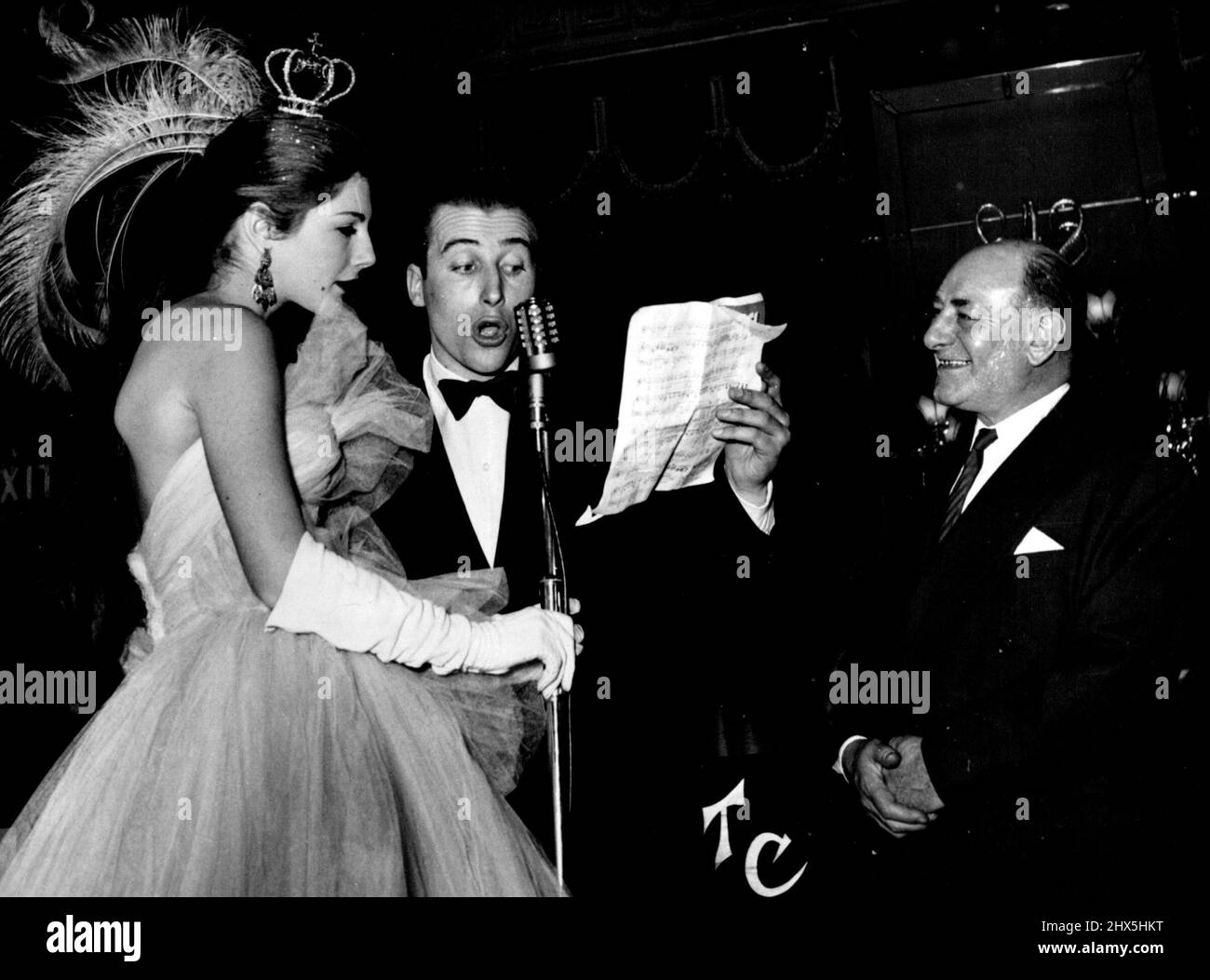 Lord 'Porchie' Porchester canta in francese a Fiona Campbell-Walter, che ha vinto il premio per il più intelligente discorso. BUD Flanagan guarda avanti in modo benigno. Lord Porchester (Porchie) canta in francese al modello sociale Fiona Campbell-Walter (Miss Park Lane), che ha vinto il premio per la più intelligente headdress. Marzo 13, 1953. (Foto dell'Agenzia Generale della Stampa della Società). Foto Stock