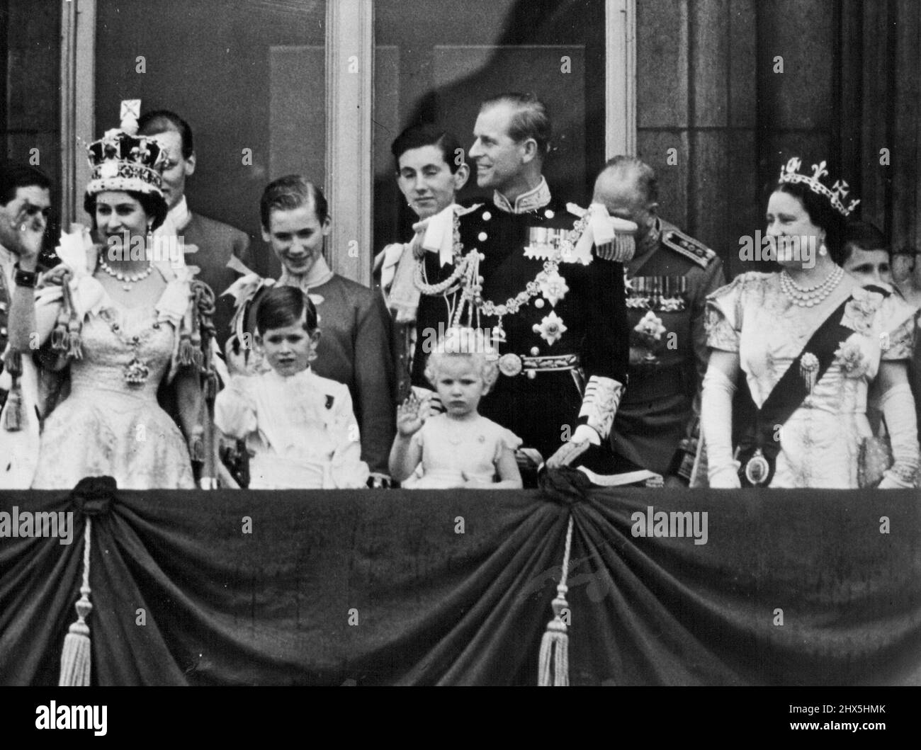 Sua Maestà saluta i suoi soggetti -- alle centinaia di migliaia dei suoi soggetti e molti visitatori stranieri, la sua maestà, ondeggia un saluto amichevole dal balcone del palazzo questa sera.....con la regina può essere visto la regina... Il duca di Edimburgo...la principessa Margaret... Il duca di Gloucester... il principe Carlo e la principessa Anne. Lo stesso posto, un tempo diverso.. Un flashback a 1953 quando la famiglia reale si è levata in piedi sullo stesso balcone dopo l'incoronazione. Giugno 02, 1953. (Foto di Paul Popper) Foto Stock
