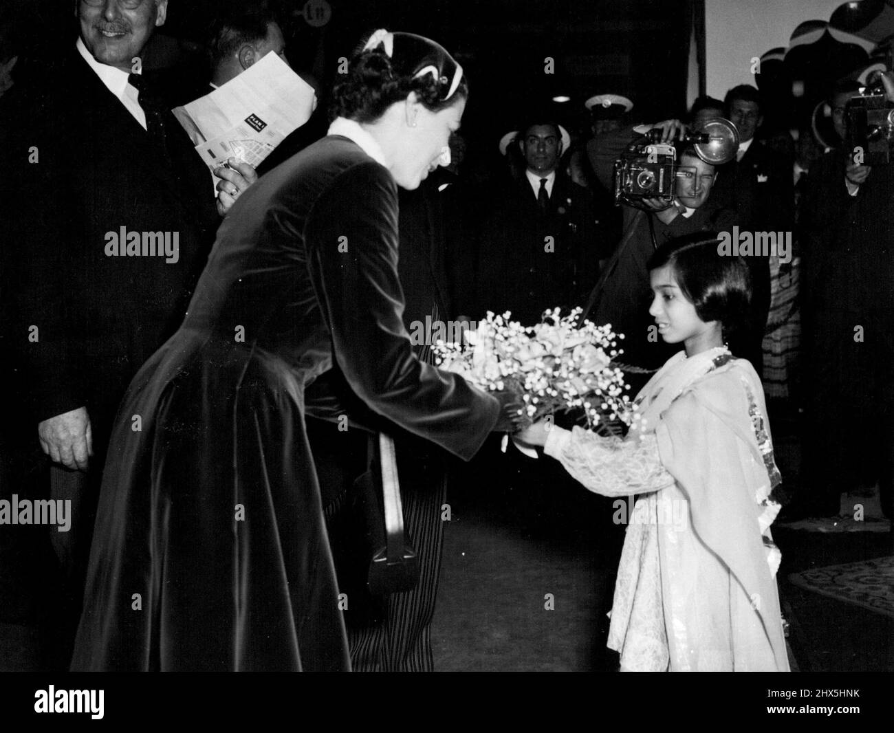 Quando la regina visitò la British Industries Fair a Londra martedì, le fu presentato due mazzi. Qui Savath, figlia dell'Alto Commissario del Pakistan a Londra, presenta uno dei mazzi alla Regina. Maggio 11, 1955. (Foto di sera immagine standard). Foto Stock