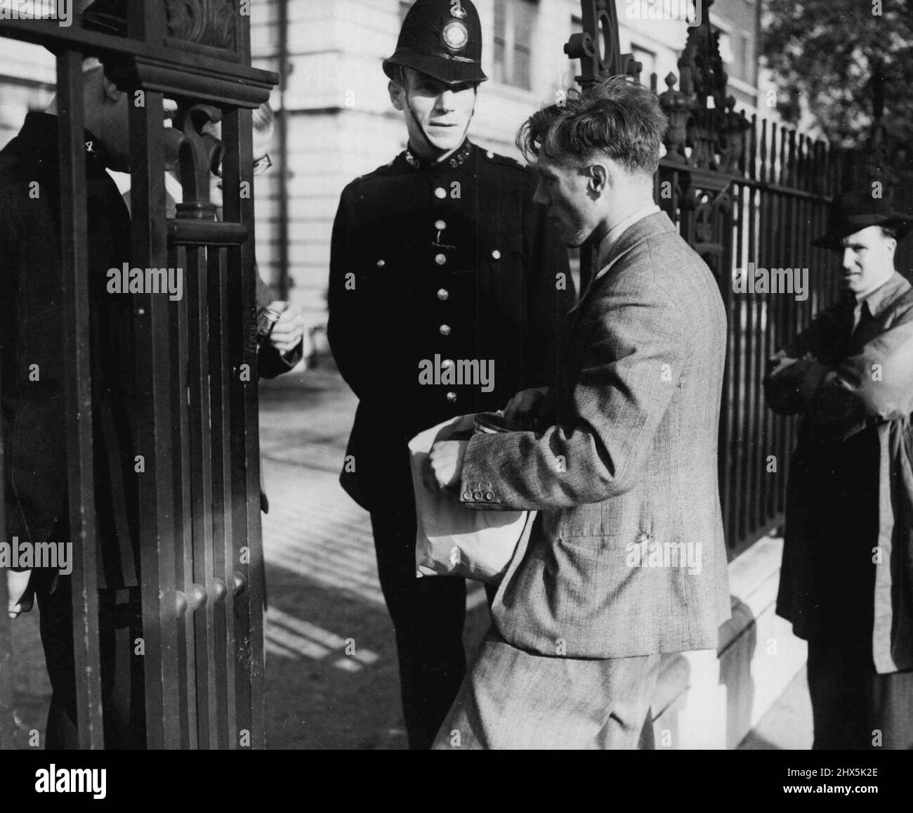 Cibo per Squatters -- Un simpatizzante porta cibo agli squatters ora saldamente installato ***** Abbey Lodge appartamenti di lusso, North London. La polizia precedente aveva assediato ***** il blocco. Le famiglie invagiate versavano lattine di vernice bianca dal ***** windows su agenti di polizia che si trovano sotto'. Ottobre 18, 1946. (Foto per funzioni speculare). Foto Stock