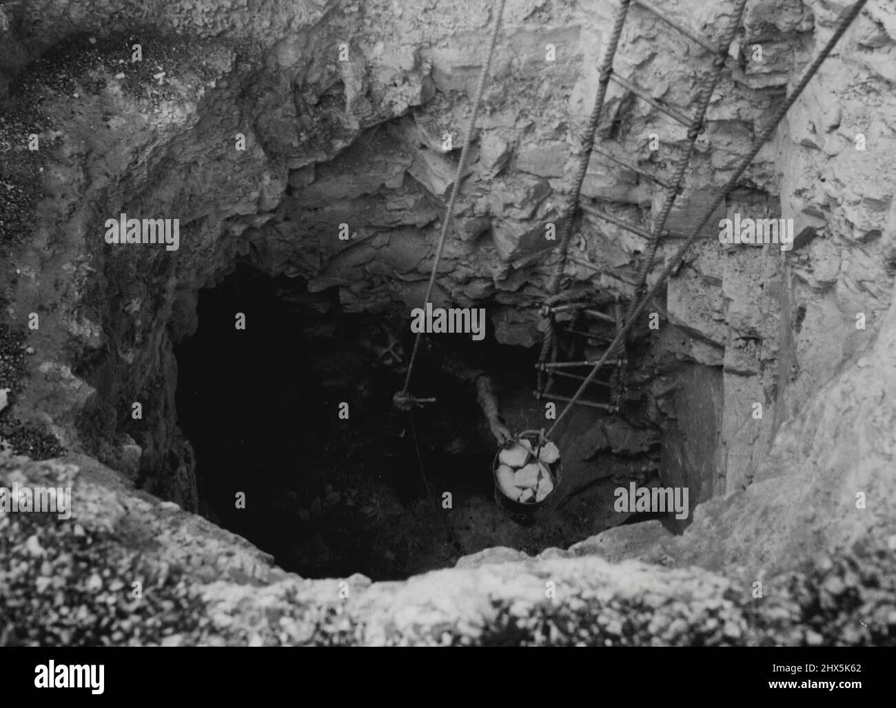 Torna all'età della pietra -- l'ingresso con materiale che viene trasportato in su in un secchio. I membri della Worthing Archaeological Society stavano esplorando oggi l'interno di una miniera di selce neolitica a Cissbury Hill sul Sussex Downs, per trovare le basi di Stone Age Britons. Settembre 20, 1953. (Foto per foto del contratto della posta giornaliera). Foto Stock