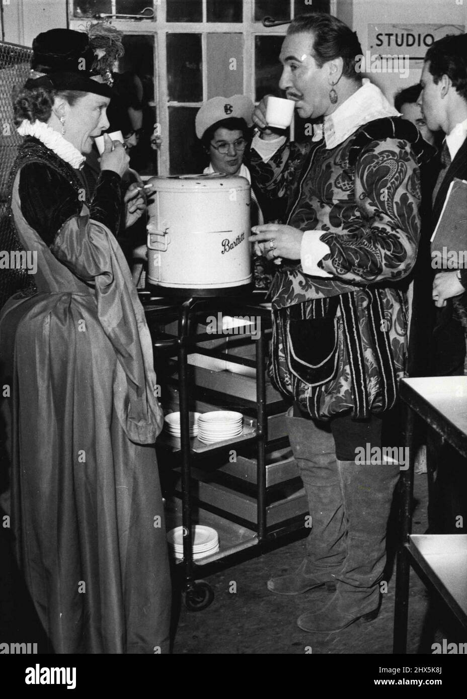 Un 'cavalier' di buckling si ferma per una tazza di tè. È attore Donald Wolfit, vestito per la sua parte in un gioco di costume per la televisione. Febbraio 12, 1954. (Foto di Daily Mirror). Foto Stock